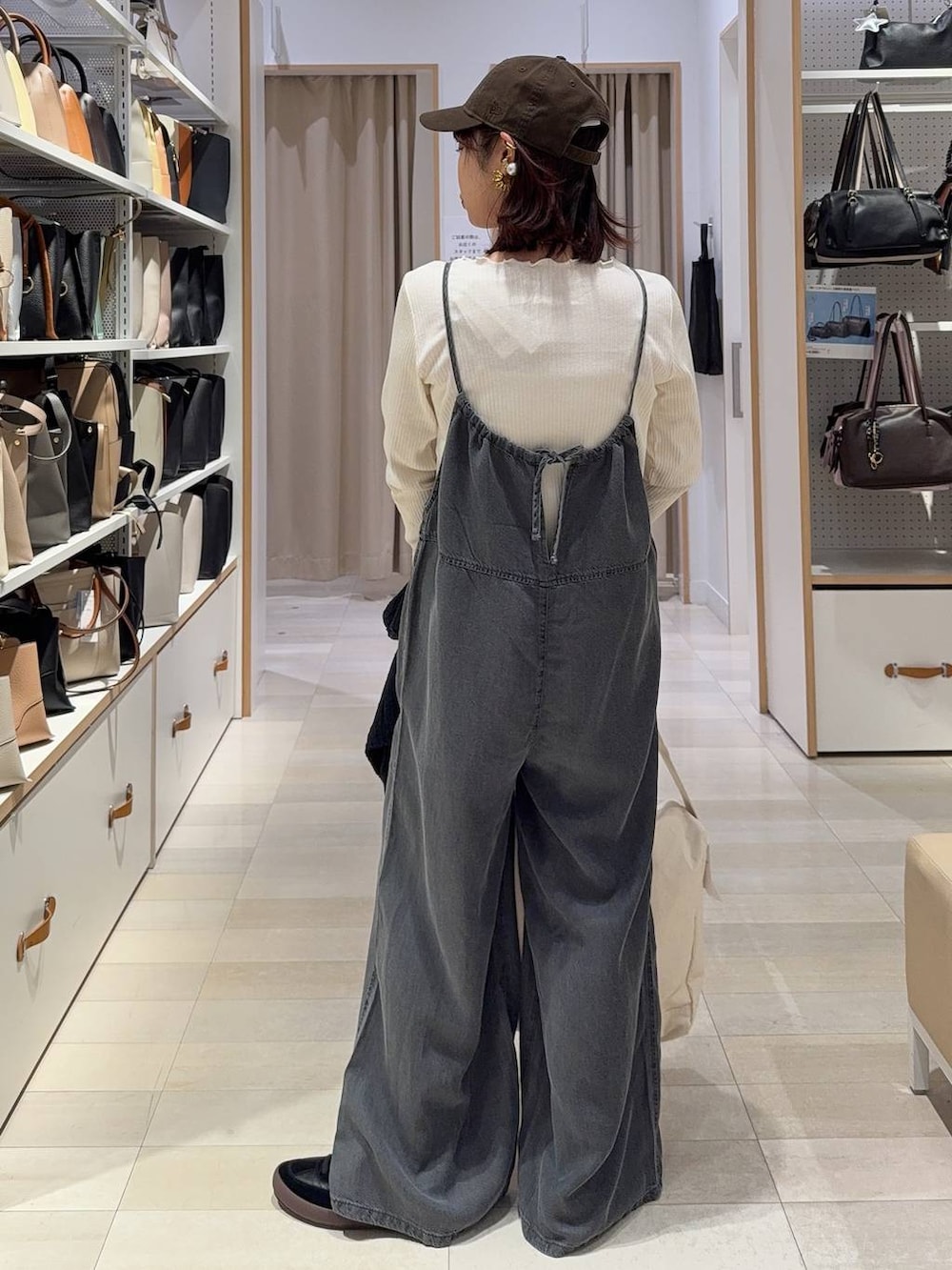 ブラック系のスニーカー、ベージュ系のショルダーバッグ、ホワイト系のTシャツ/カットソーを着用したレディースの春コーディネートの6枚目の写真