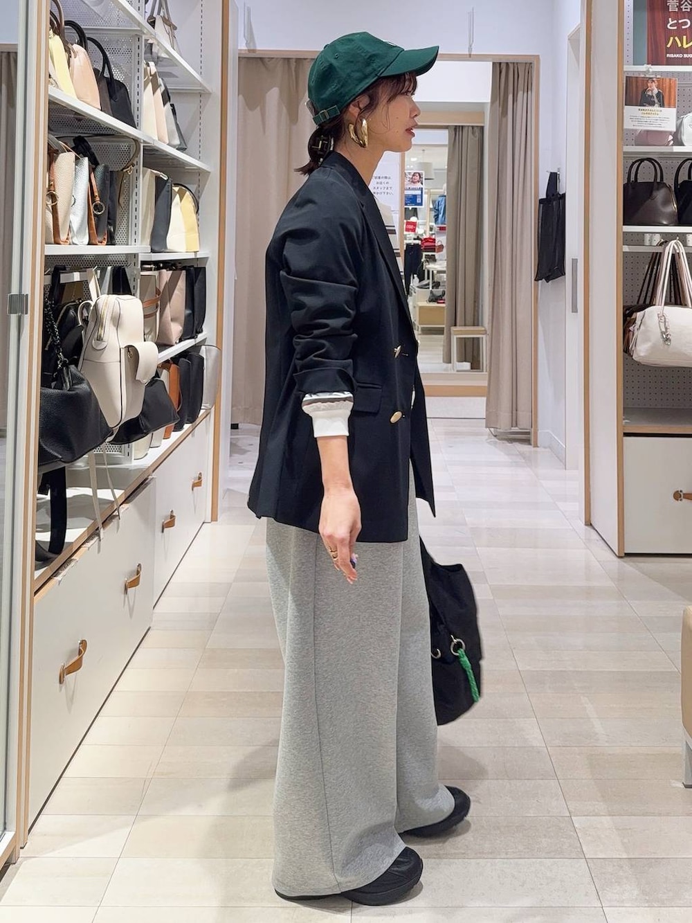 ブラック系のスニーカー、ブラック系のトートバッグ、ブルー系のテーラードジャケットを着用したレディースの冬コーディネートの5枚目の写真