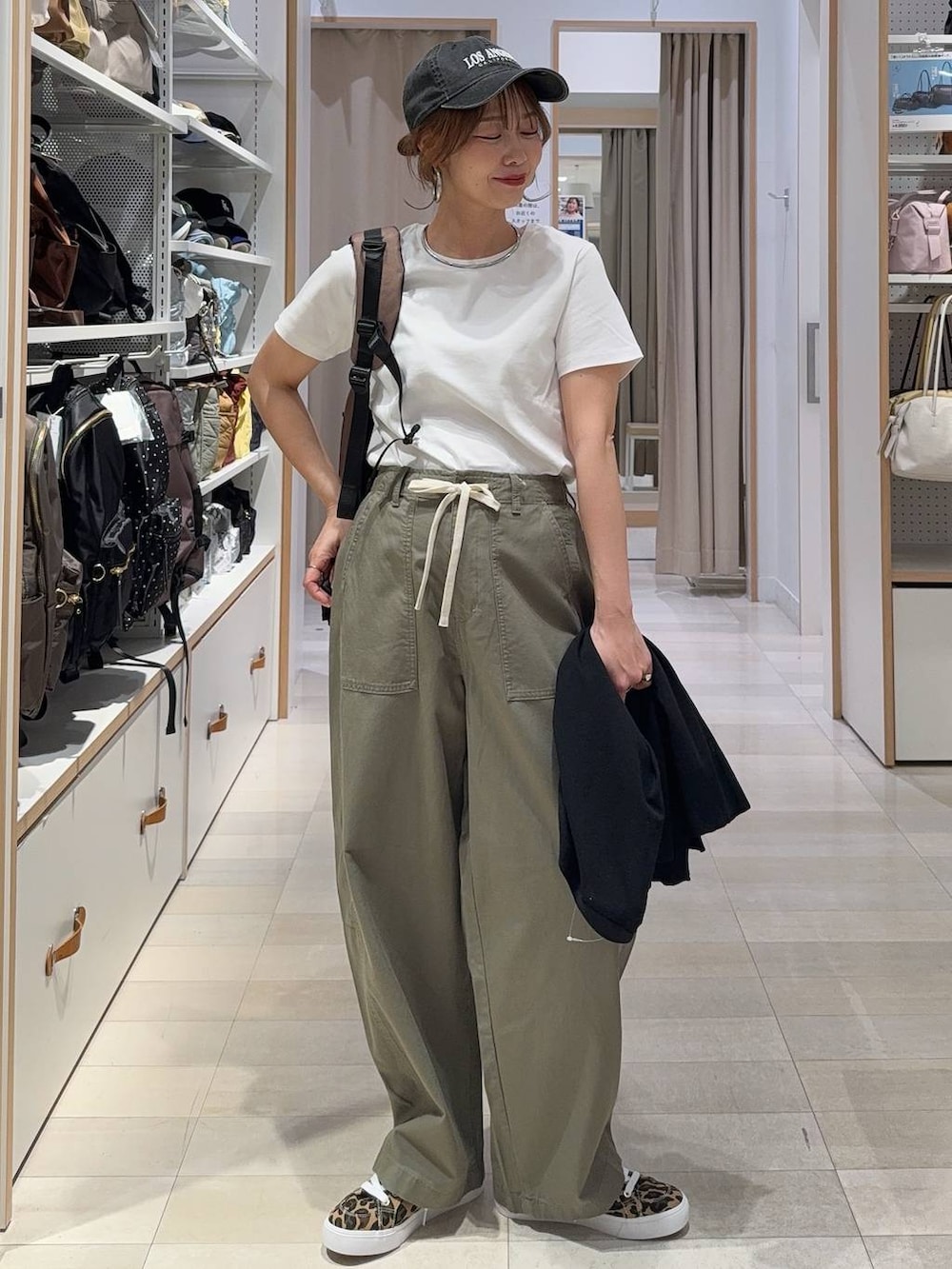 グリーン系のその他パンツ、その他のスニーカー、ブラック系のカーディガン/ボレロを着用したレディースの春コーディネートの3枚目の写真