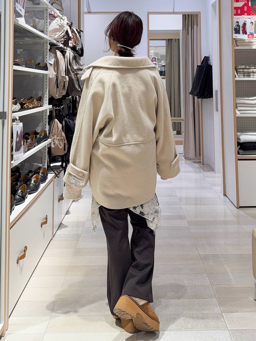 ブラック系のショルダーバッグ、イエロー系のブーツ、ホワイト系のニット/セーターを着用したレディースの冬コーディネートの7枚目の写真