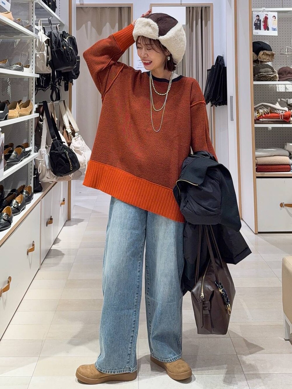 ブラック系のショルダーバッグ、ブラウン系のシャツ/ブラウス、イエロー系のブーツを着用したレディースの冬コーディネートの6枚目の写真