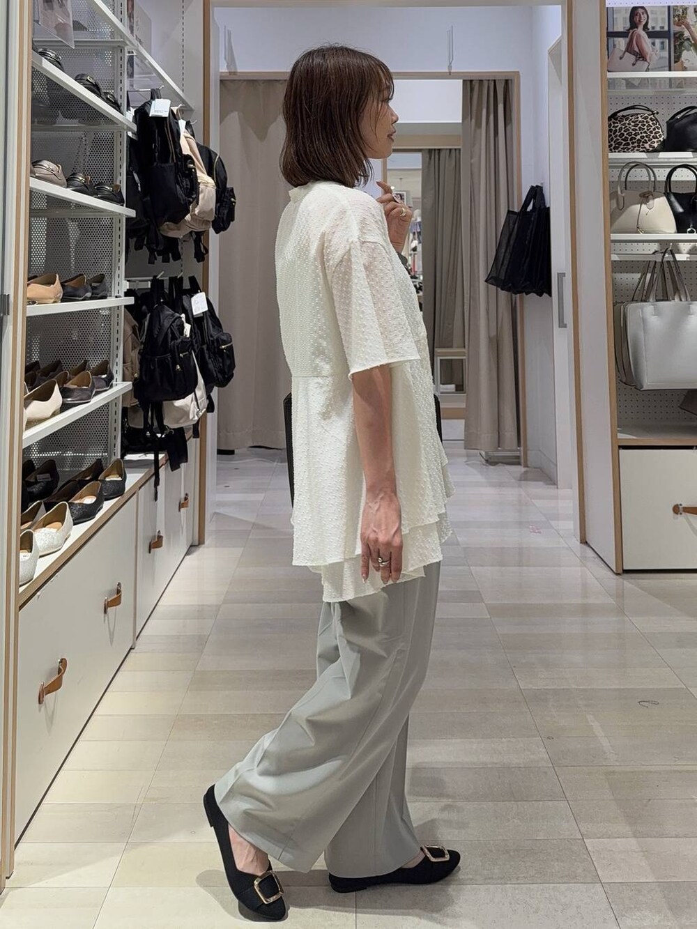 ブラック系のトートバッグ、ブラック系のパンプス、グレー系のその他パンツを着用したレディースの夏コーディネートの5枚目の写真