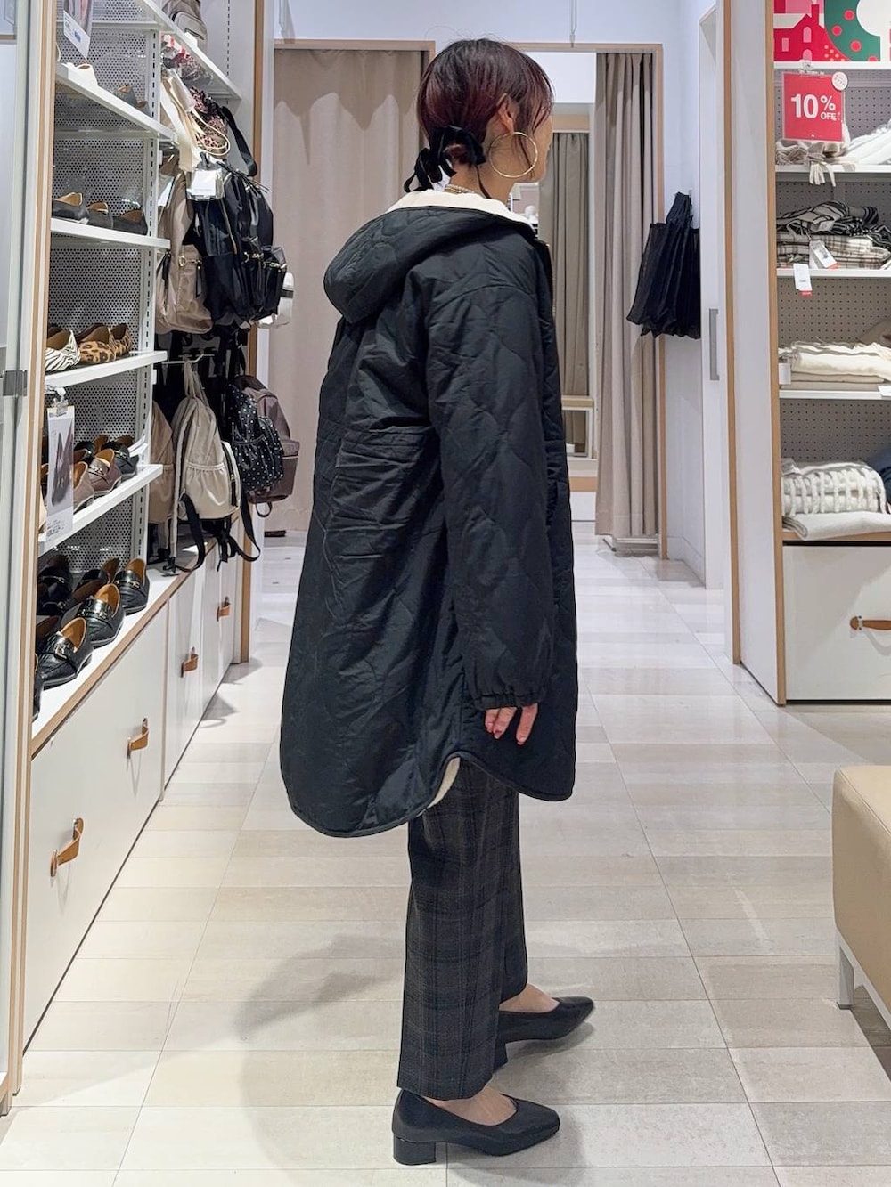 ホワイト系のショルダーバッグ、ブラック系のブルゾン、ブラック系のその他パンツを着用したレディースの冬コーディネートの4枚目の写真