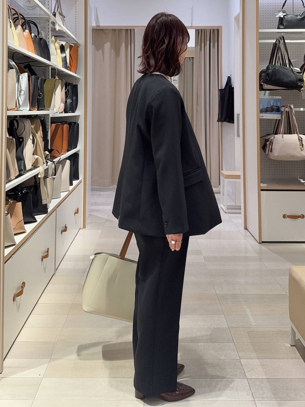 ブラック系のその他パンツ、ブラック系のテーラードジャケット、ホワイト系のトートバッグを着用したレディースの春コーディネートの5枚目の写真