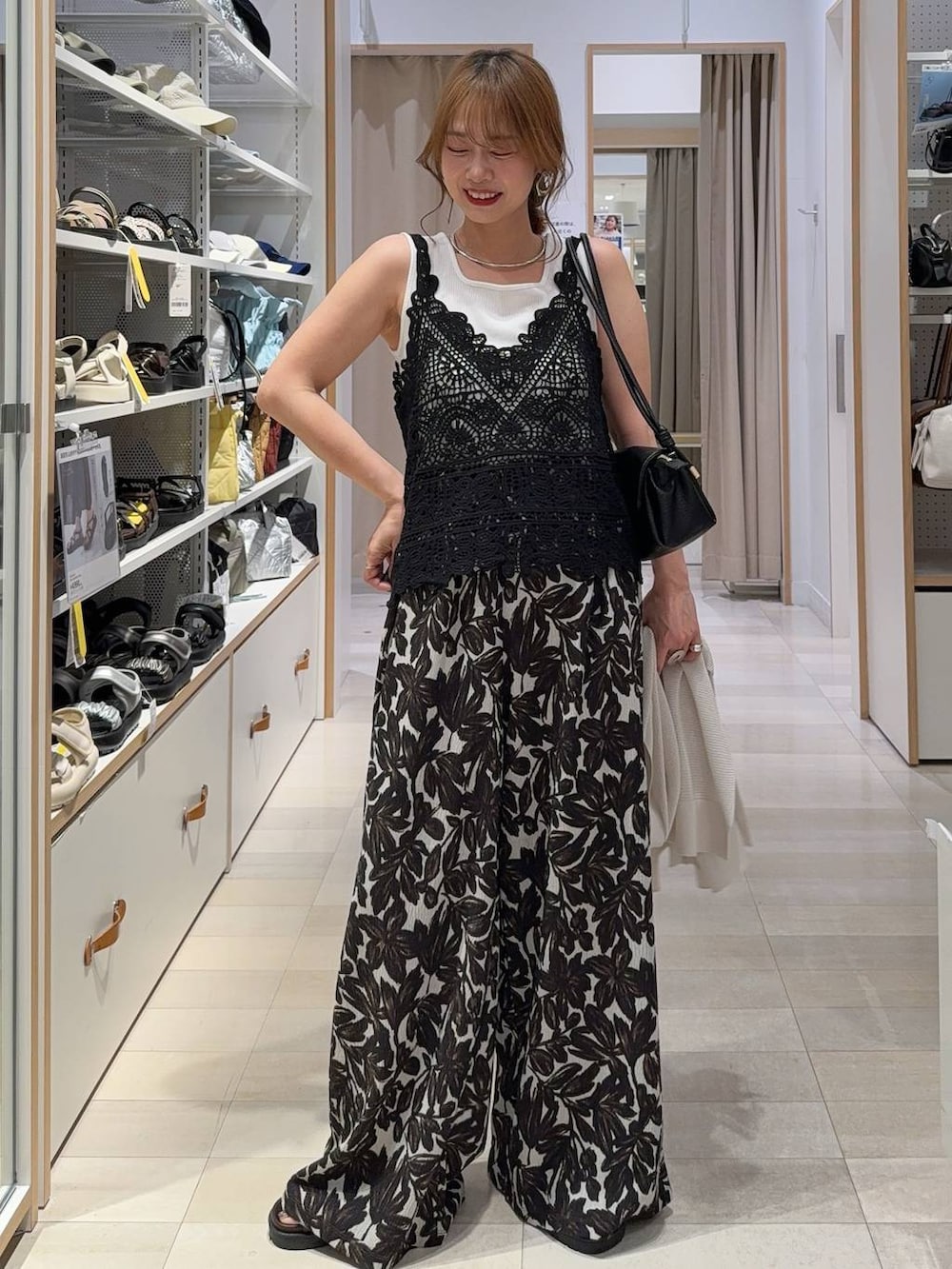 グリーン系のワンピース、ブルー系のデニムパンツ、ブラック系のサンダルを着用したレディースの夏コーディネートの3枚目の写真