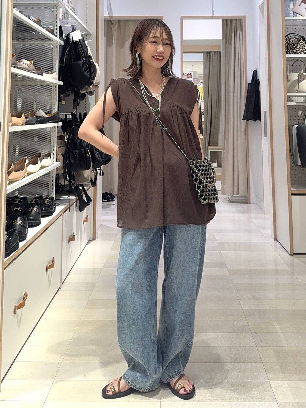 ホワイト系のデニムパンツ、グリーン系のショルダーバッグ、ブラック系のシャツ/ブラウスを着用したレディースの夏コーディネートの4枚目の写真