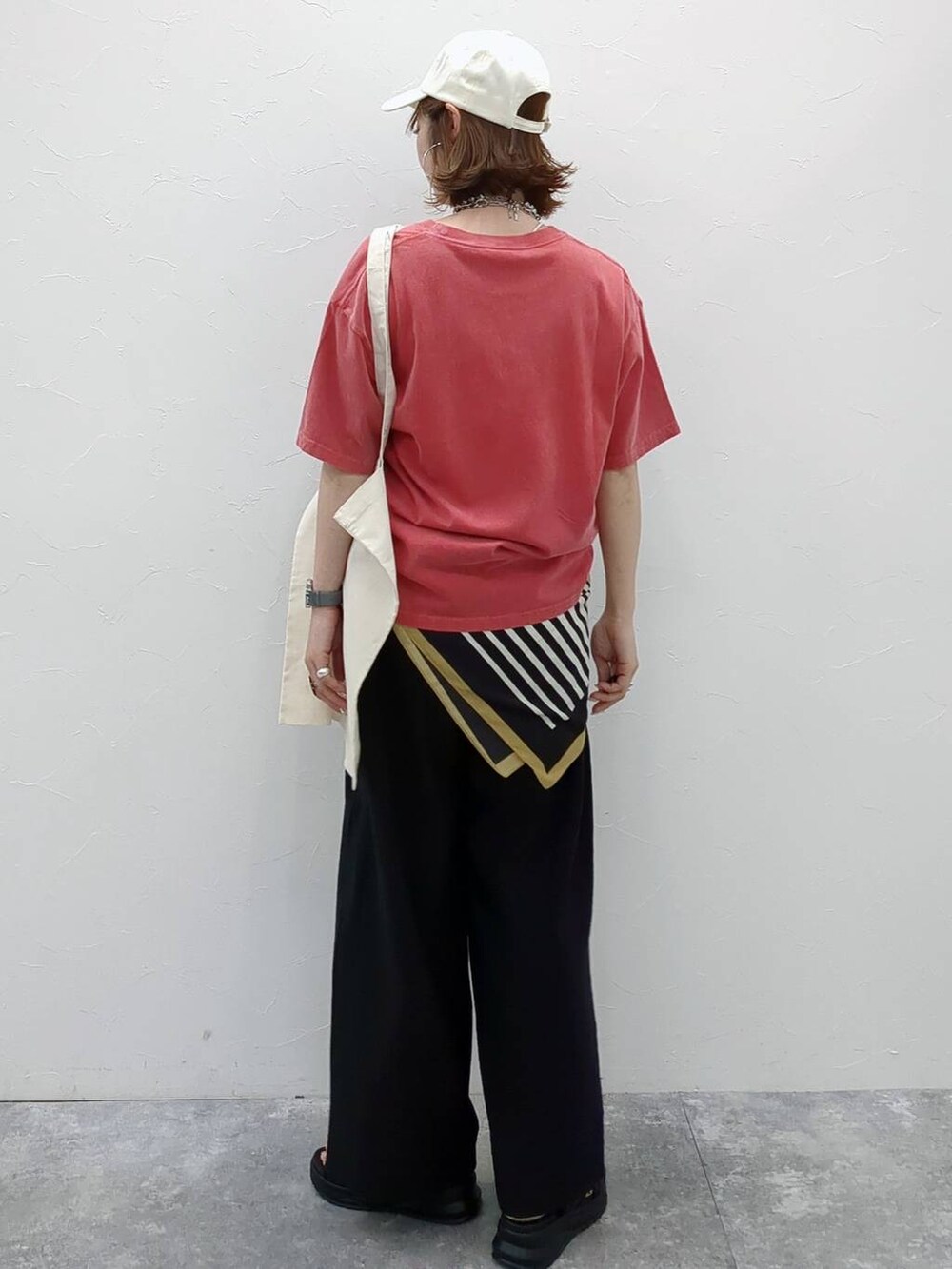 レッド系のTシャツ/カットソー、ホワイト系のトートバッグ、ホワイト系のキャップを着用したレディースの春コーディネートの3枚目の写真