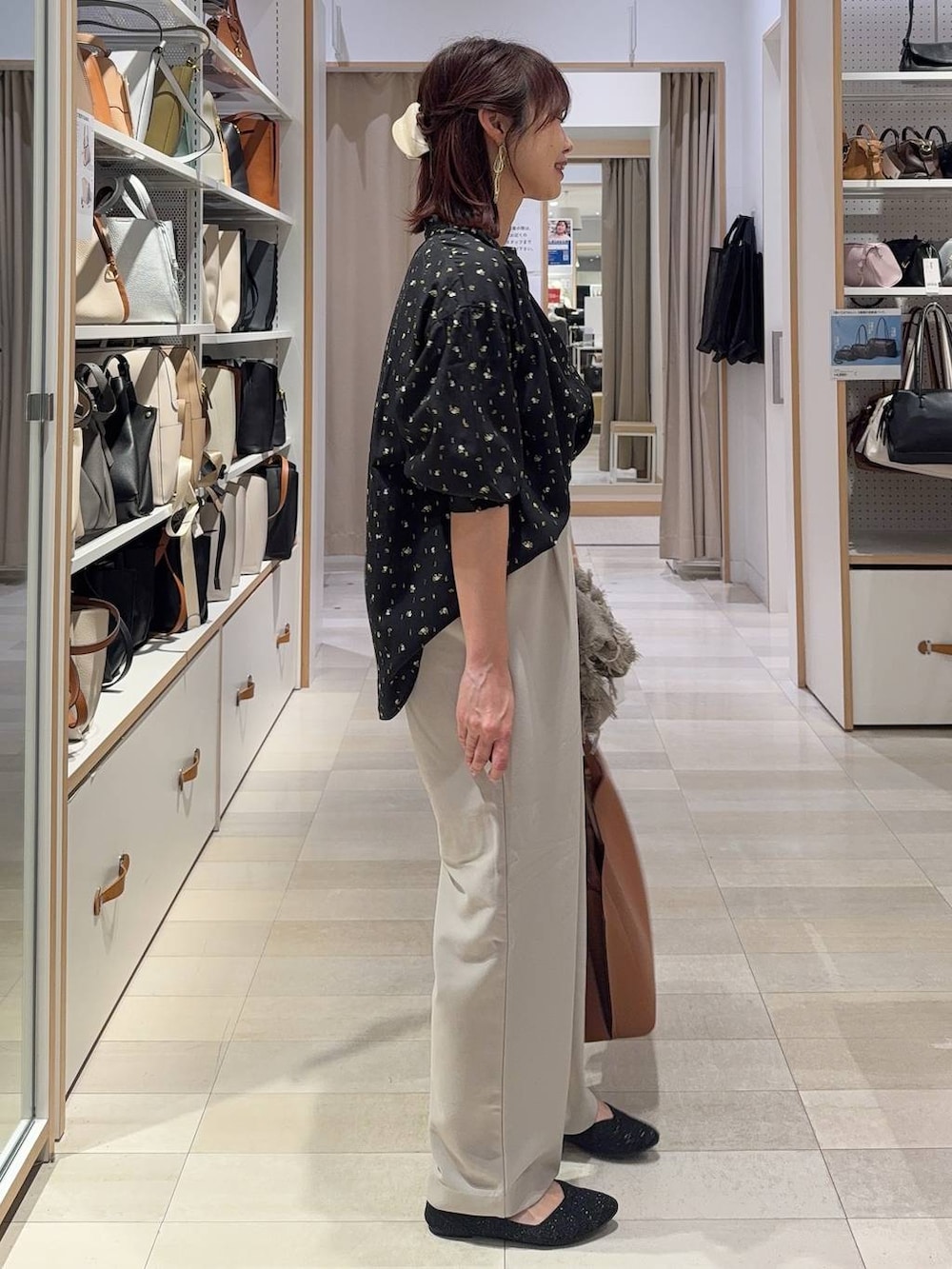 ブラック系のシャツ/ブラウス、ブラウン系のトートバッグ、ブラック系のパンプスを着用したレディースの春コーディネートの6枚目の写真