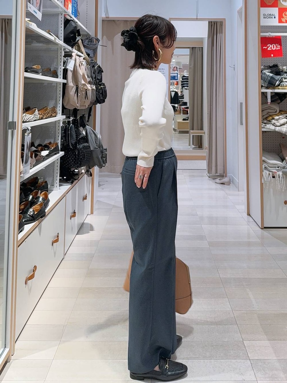 ブラック系のスニーカー、ブラック系のボストンバッグ、ホワイト系のニット/セーターを着用したレディースの冬コーディネートの6枚目の写真