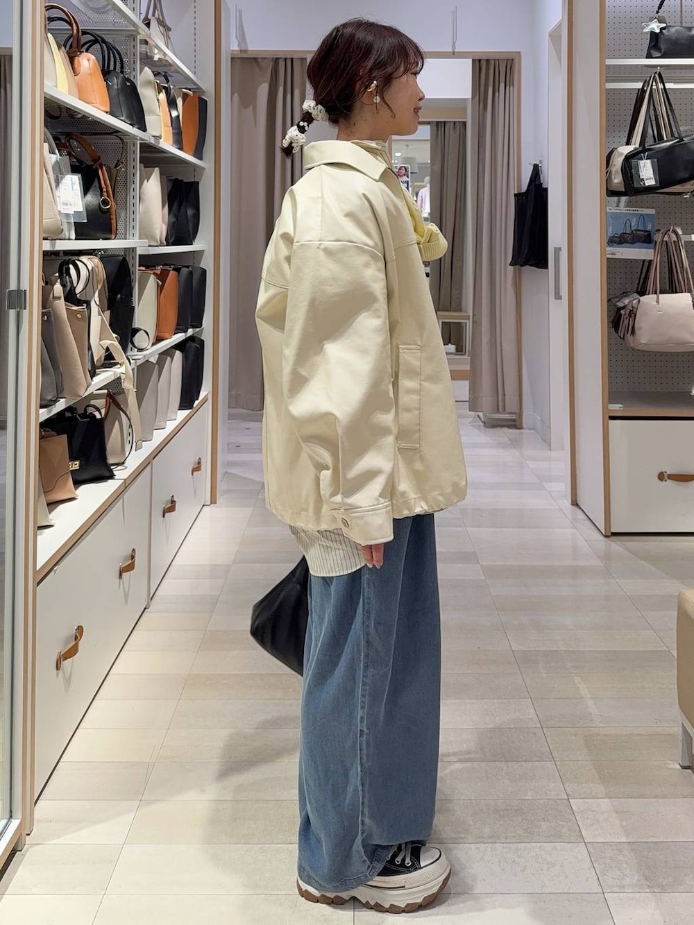 ホワイト系のブルゾン、ホワイト系のニット/セーター、イエロー系のカーディガン/ボレロを着用したレディースの春コーディネートの5枚目の写真