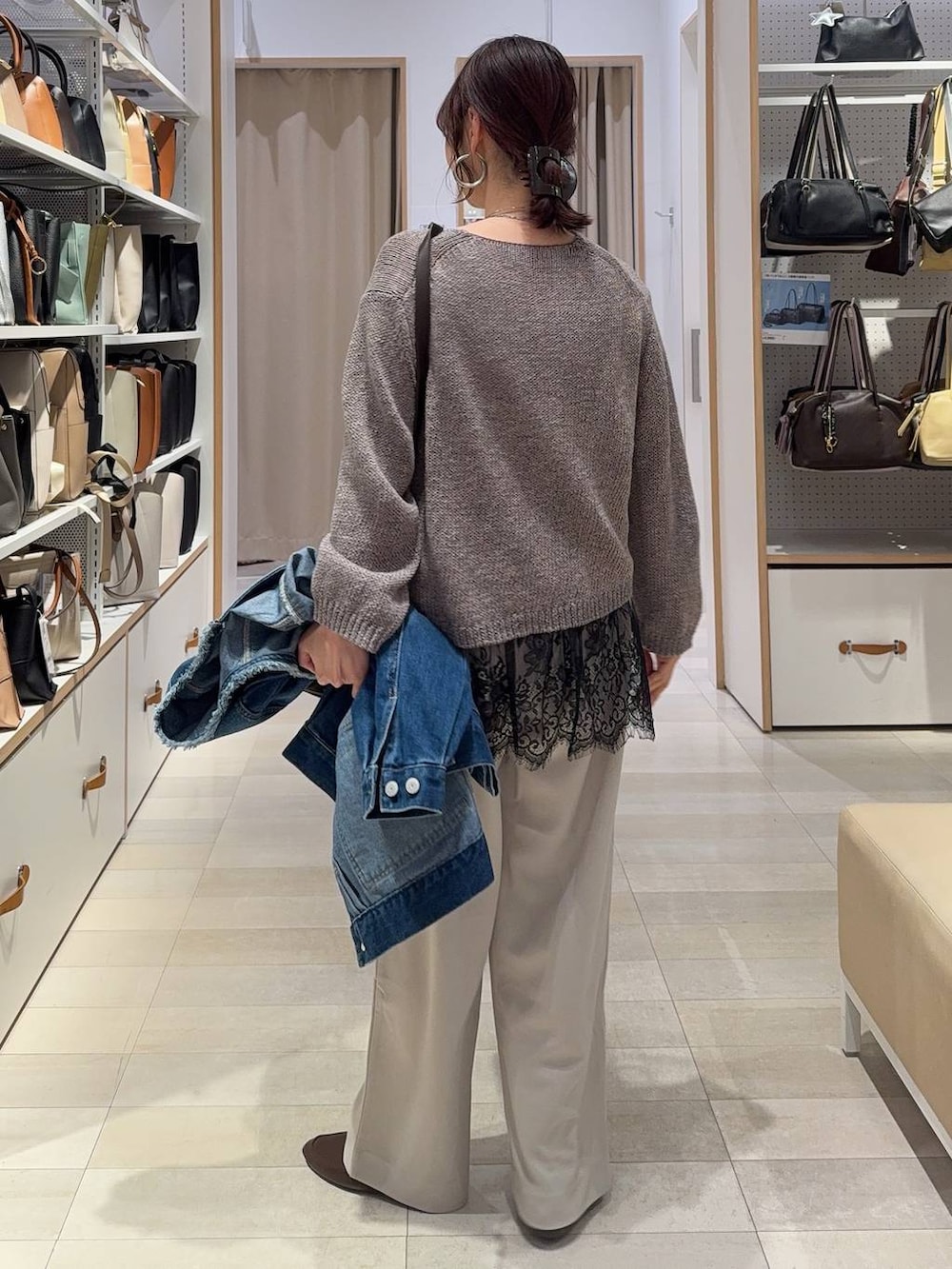 ブルー系のデニムジャケット、ブラウン系のボストンバッグ、ベージュ系のその他パンツを着用したレディースの春コーディネートの6枚目の写真