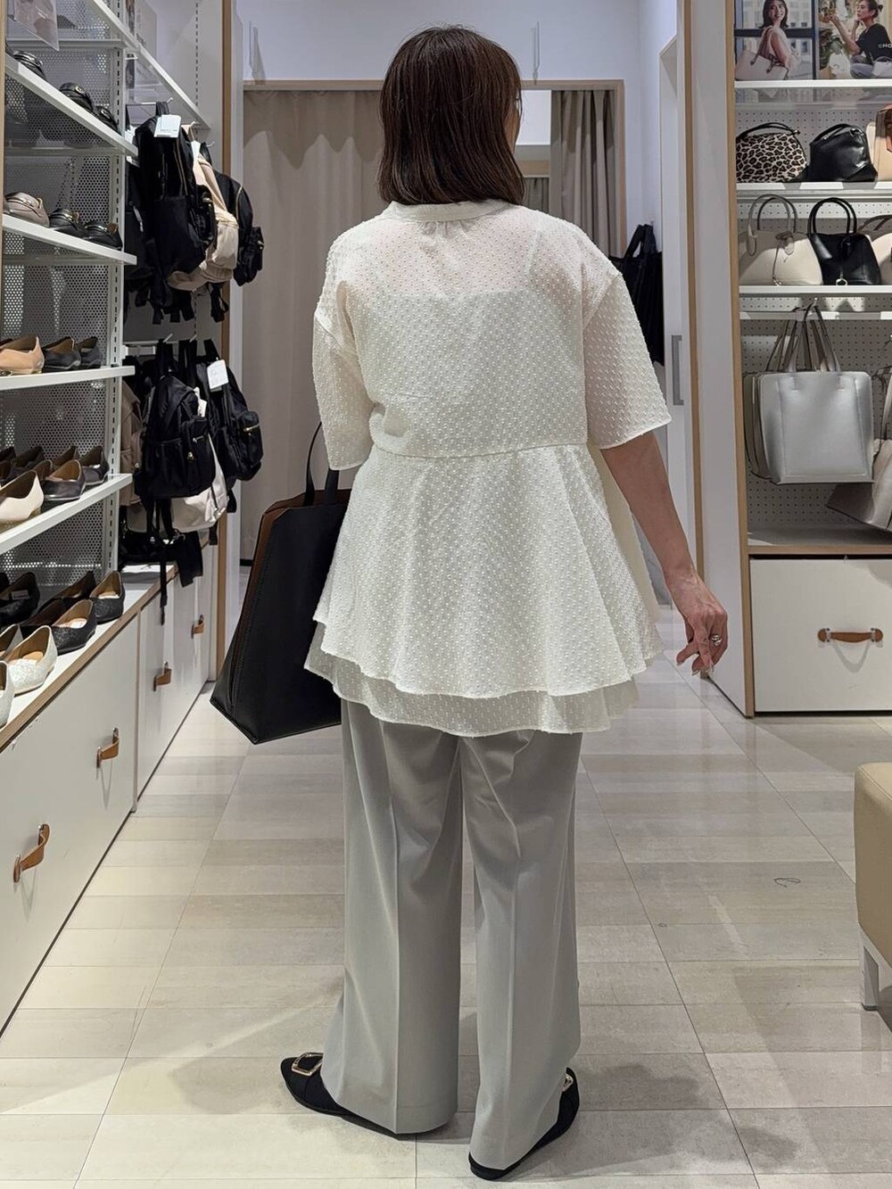 ブラック系のトートバッグ、ブラック系のパンプス、グレー系のその他パンツを着用したレディースの夏コーディネートの6枚目の写真