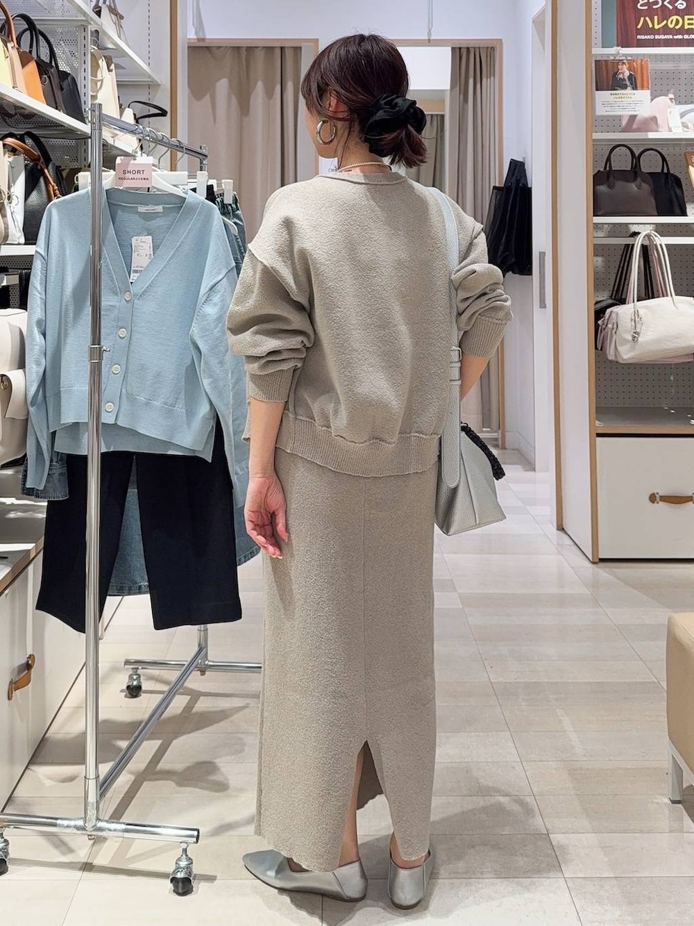 ブラック系のスニーカー、ベージュ系のワンピース、ホワイト系のTシャツ/カットソーを着用したレディースの春コーディネートの9枚目の写真