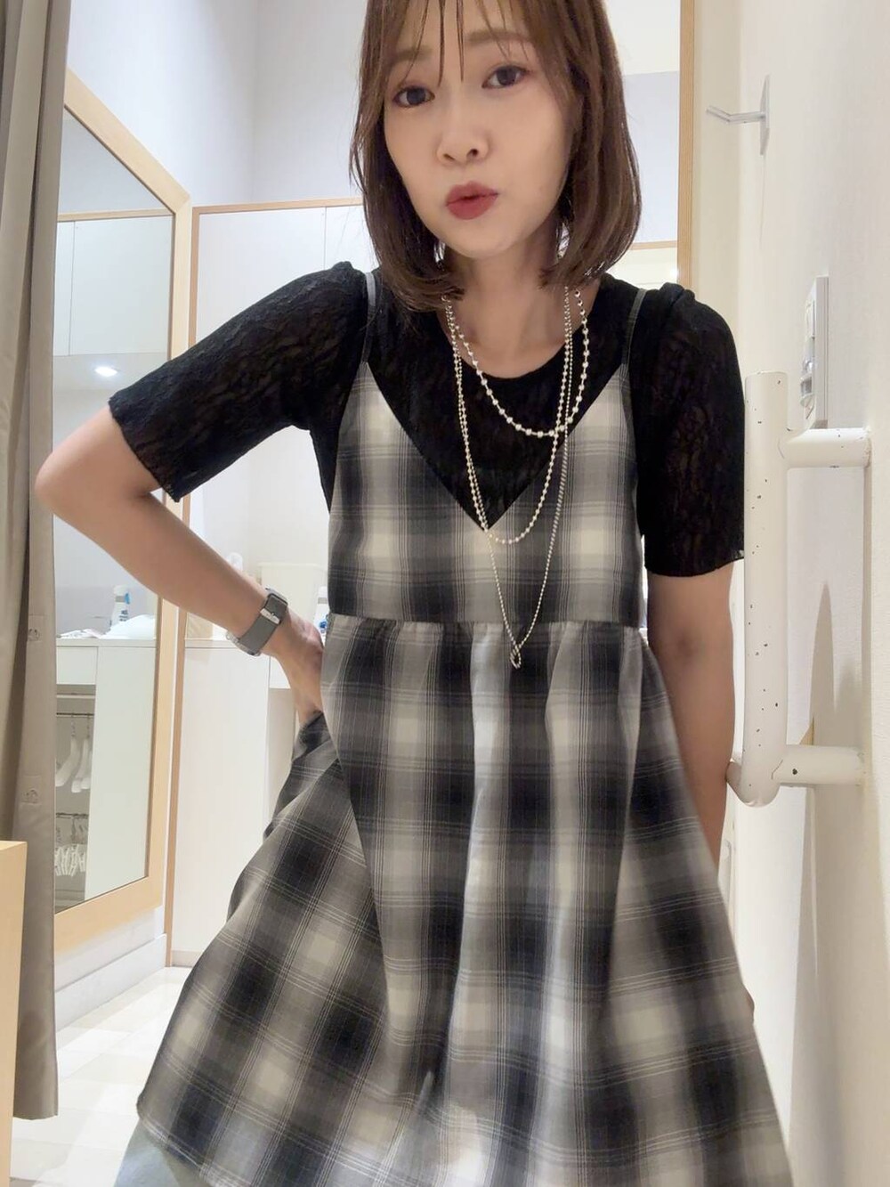 ブルー系のデニムパンツ、ホワイト系のキャミソール、ブラック系のキャミソールを着用したレディースの夏コーディネートの2枚目の写真