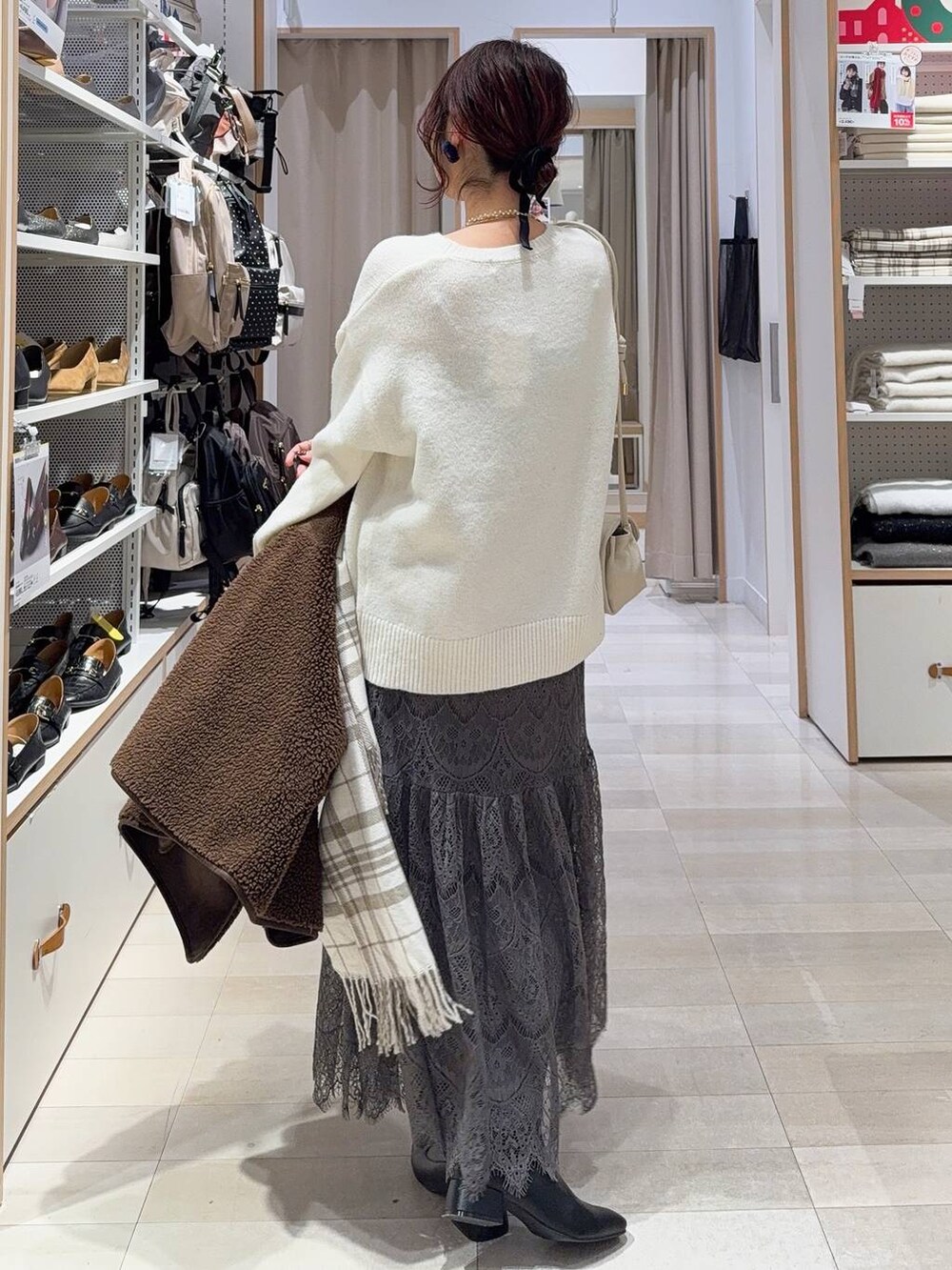 ベージュ系のショルダーバッグ、ブラック系のブーツ、ブラウン系のテーラードジャケットを着用したレディースの冬コーディネートの9枚目の写真