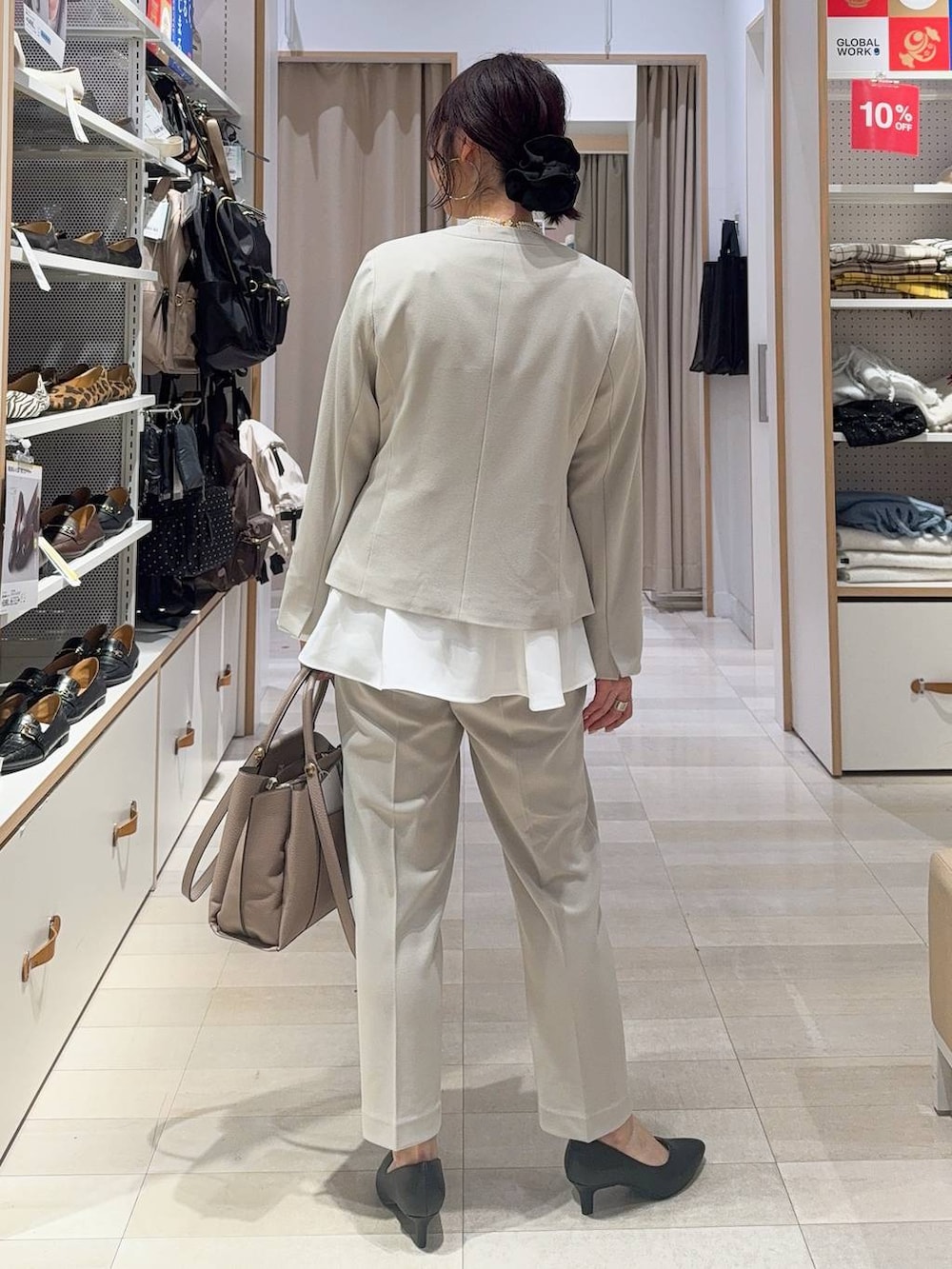 ブラック系のパンプス、ベージュ系のパンツドレス、ベージュ系のトートバッグを着用したレディースの冬コーディネートの5枚目の写真