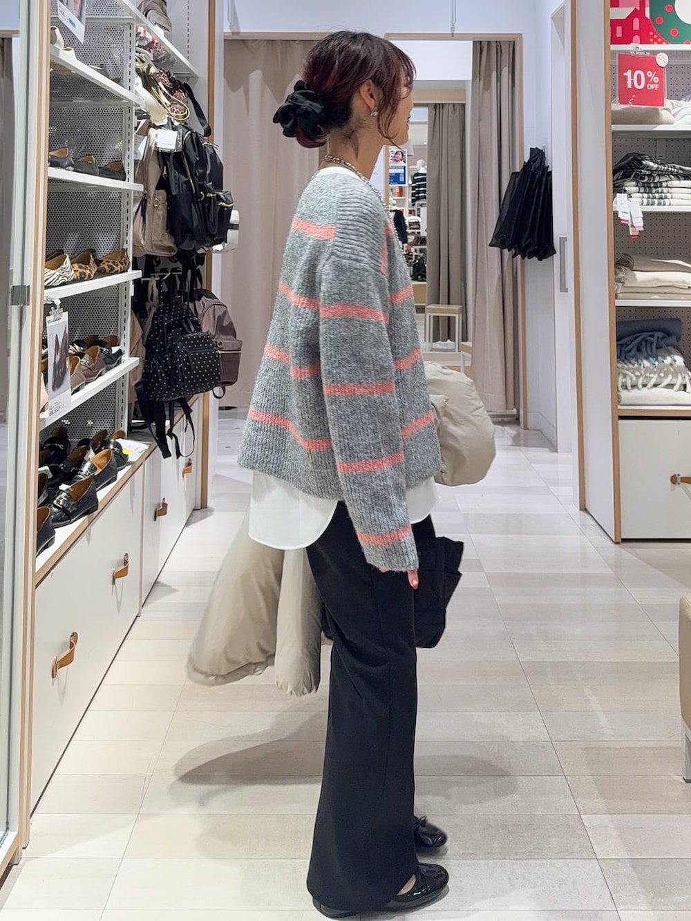 ゴールド系のバレエシューズ、ブラック系のトートバッグ、ベージュ系のダウンジャケット/コートを着用したレディースの冬コーディネートの5枚目の写真