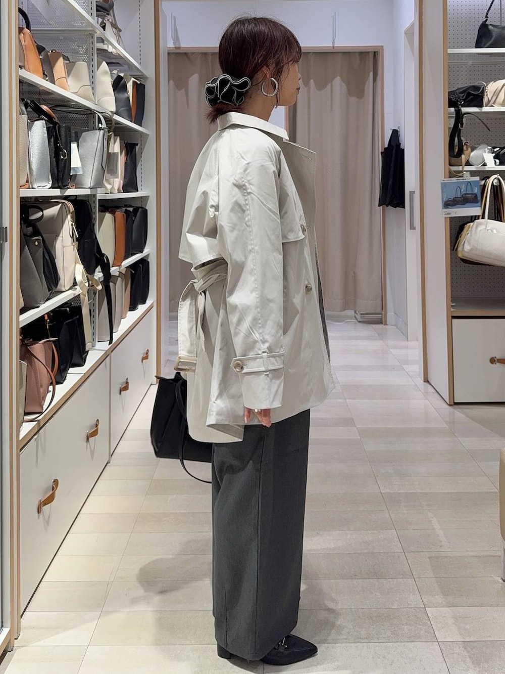 ベージュ系のトレンチコート、ブラック系のトートバッグ、グレー系のその他パンツを着用したレディースの春コーディネートの4枚目の写真