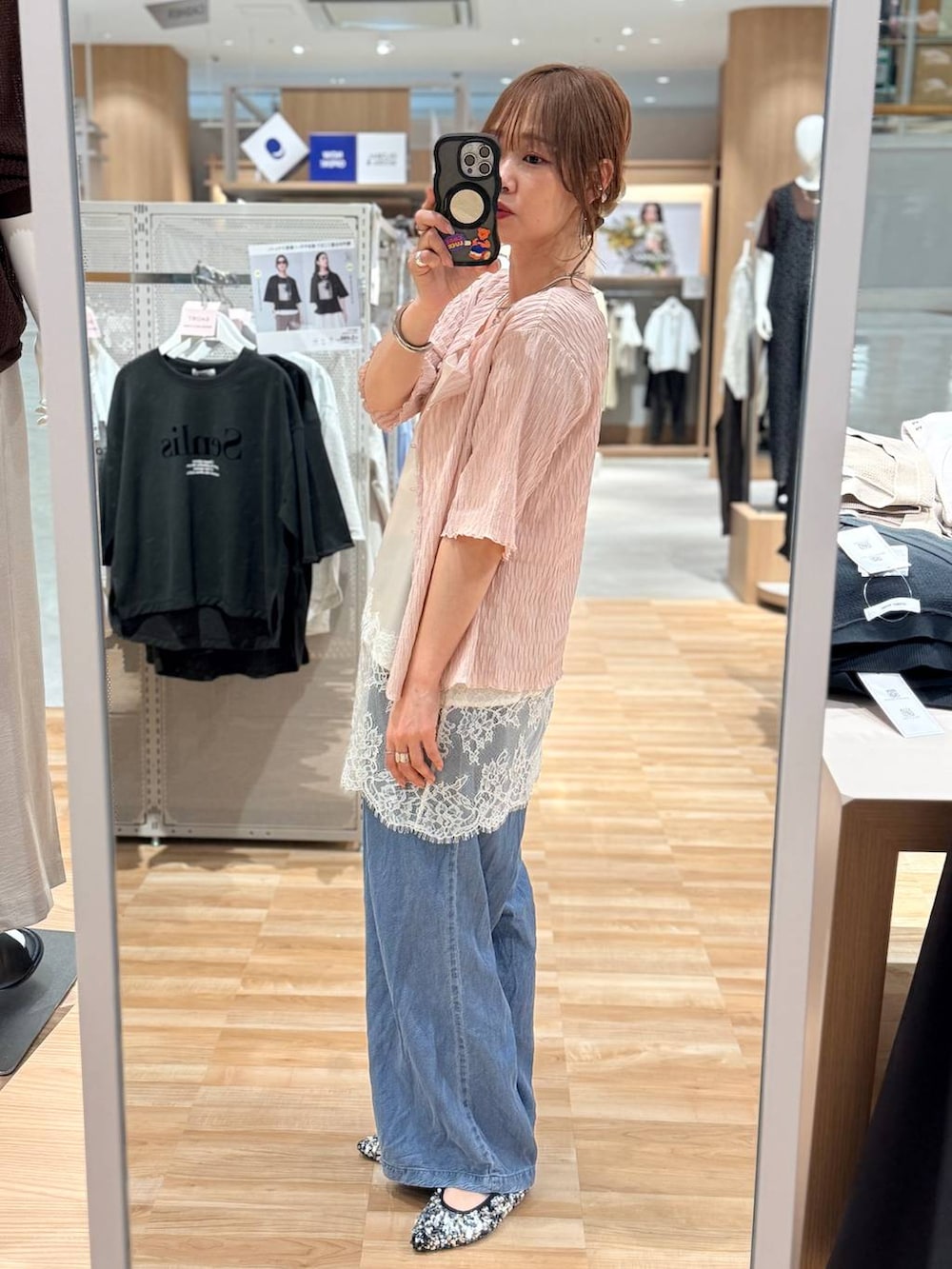 ホワイト系のキャミソール、ブルー系のデニムパンツ、シルバー系のネックレスを着用したレディースの春コーディネートの3枚目の写真