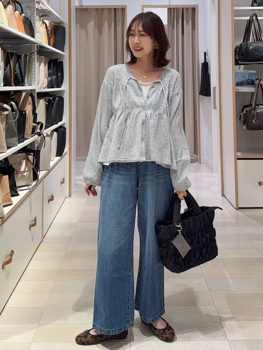 ブラック系のトートバッグ、ブラック系のマウンテンパーカー、グレー系のスカートを着用したレディースの春コーディネートの3枚目の写真