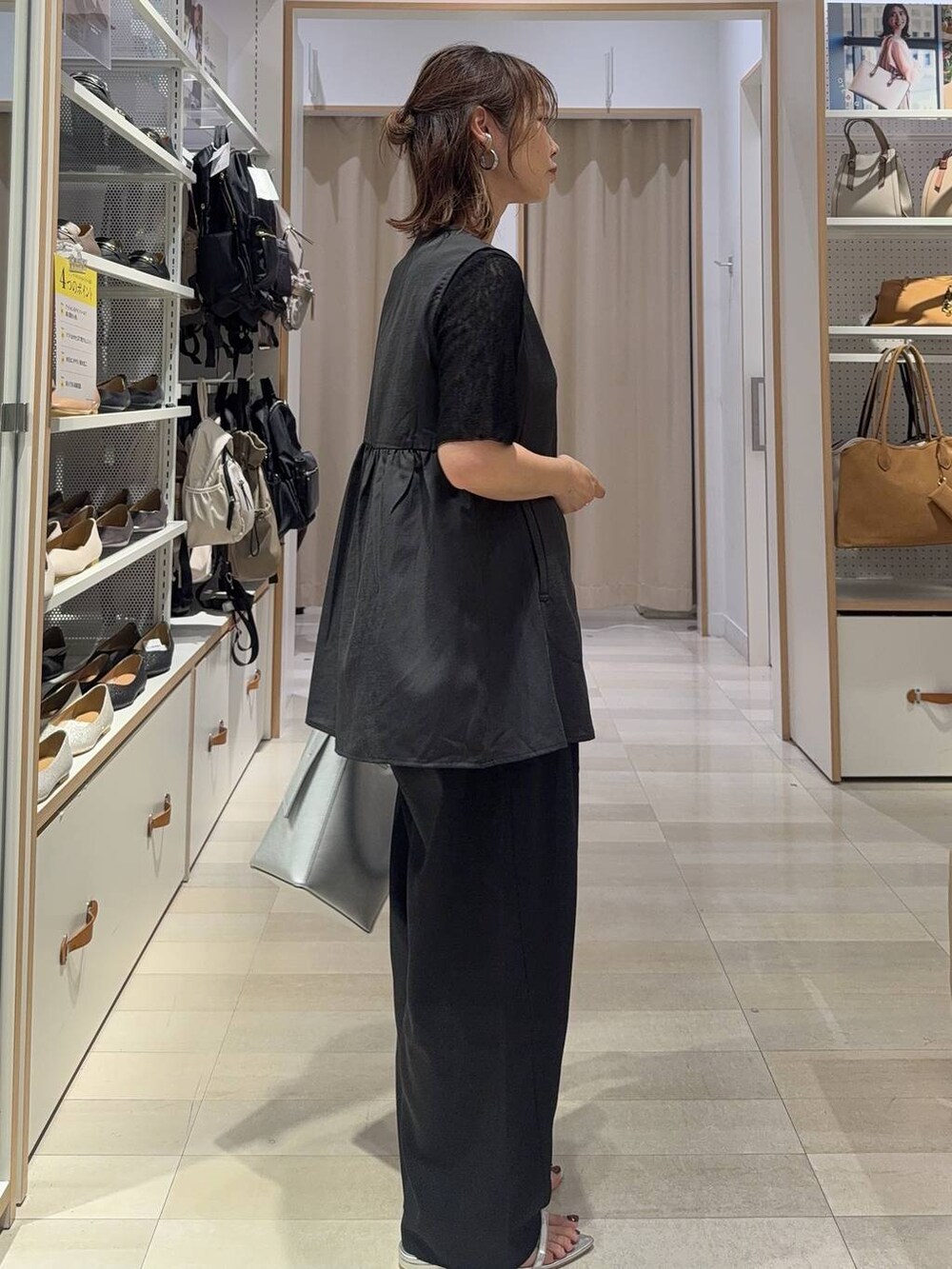 シルバー系のショルダーバッグ、ブラック系のTシャツ/カットソー、シルバー系のサンダルを着用したレディースの夏コーディネートの5枚目の写真