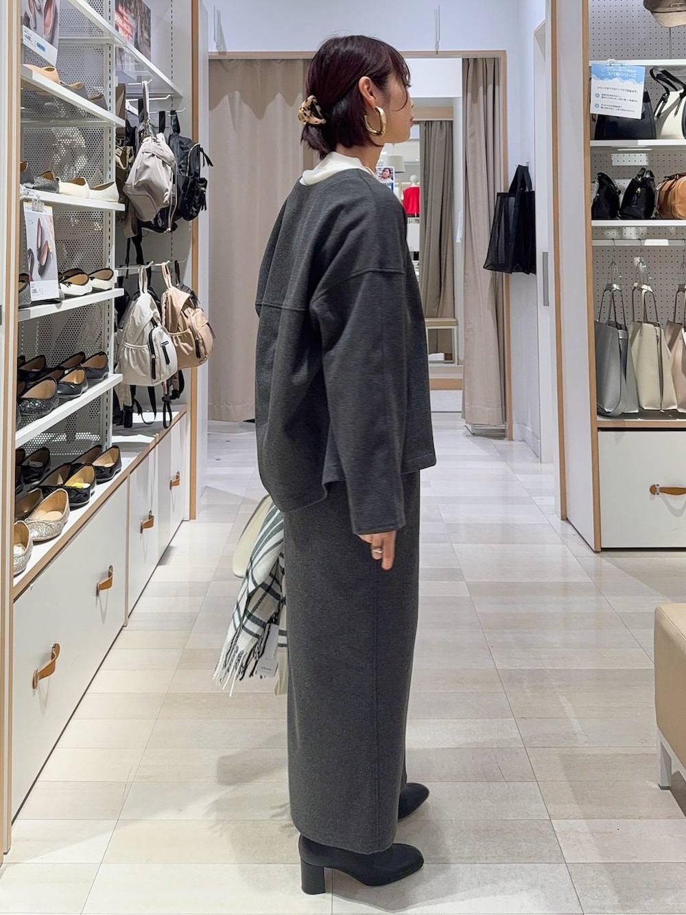 ホワイト系のショルダーバッグ、ブラック系のブーツ、ブラウン系のバレッタ/ヘアクリップを着用したレディースの秋コーディネートの4枚目の写真