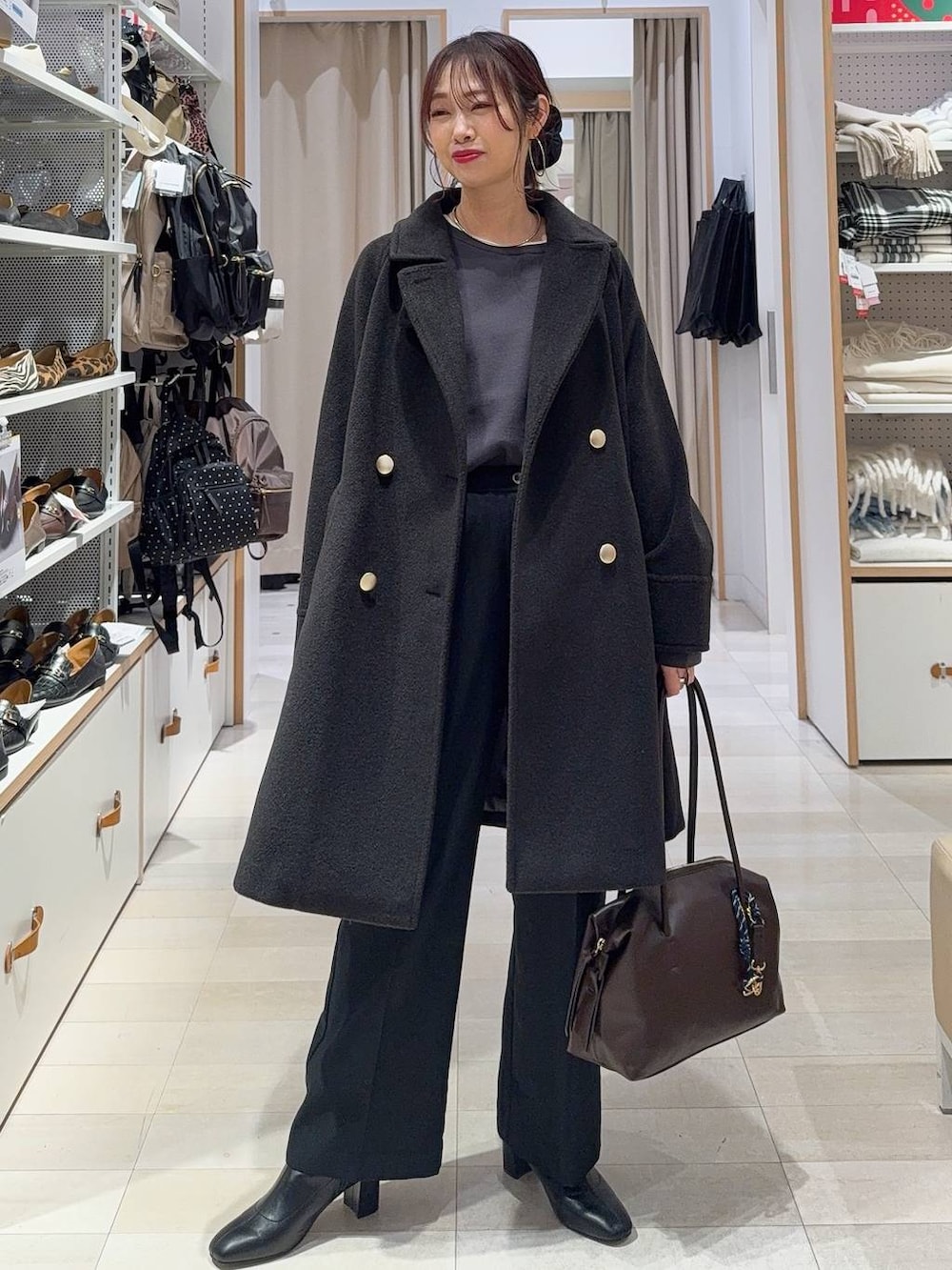 ブラック系のチェスターコート、グレー系のその他パンツ、ブラック系のスニーカーを着用したレディースの冬コーディネートの6枚目の写真