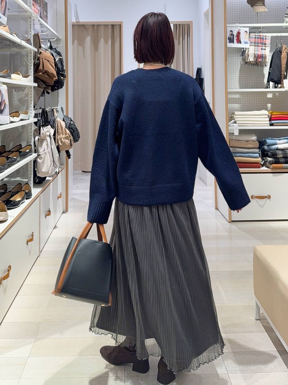 ブラック系のトートバッグ、ブラウン系のノーカラージャケット、シルバー系のネックレスを着用したレディースの秋コーディネートの6枚目の写真