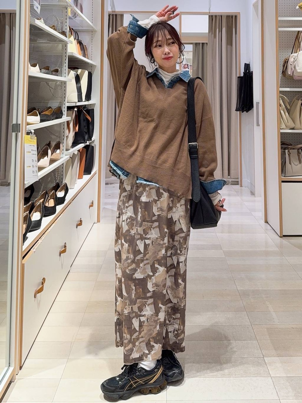 ブラウン系のニット/セーター、ホワイト系のTシャツ/カットソー、ブルー系のシャツ/ブラウスを着用したレディースの冬コーディネートの2枚目の写真