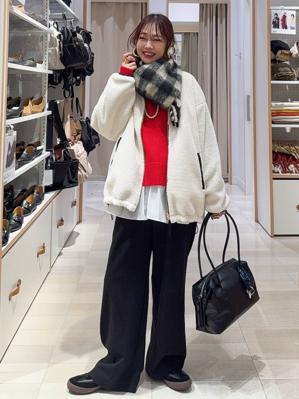 ブラック系のスニーカー、ブラウン系のボストンバッグ、ホワイト系のブルゾンを着用したレディースの冬コーディネートの3枚目の写真