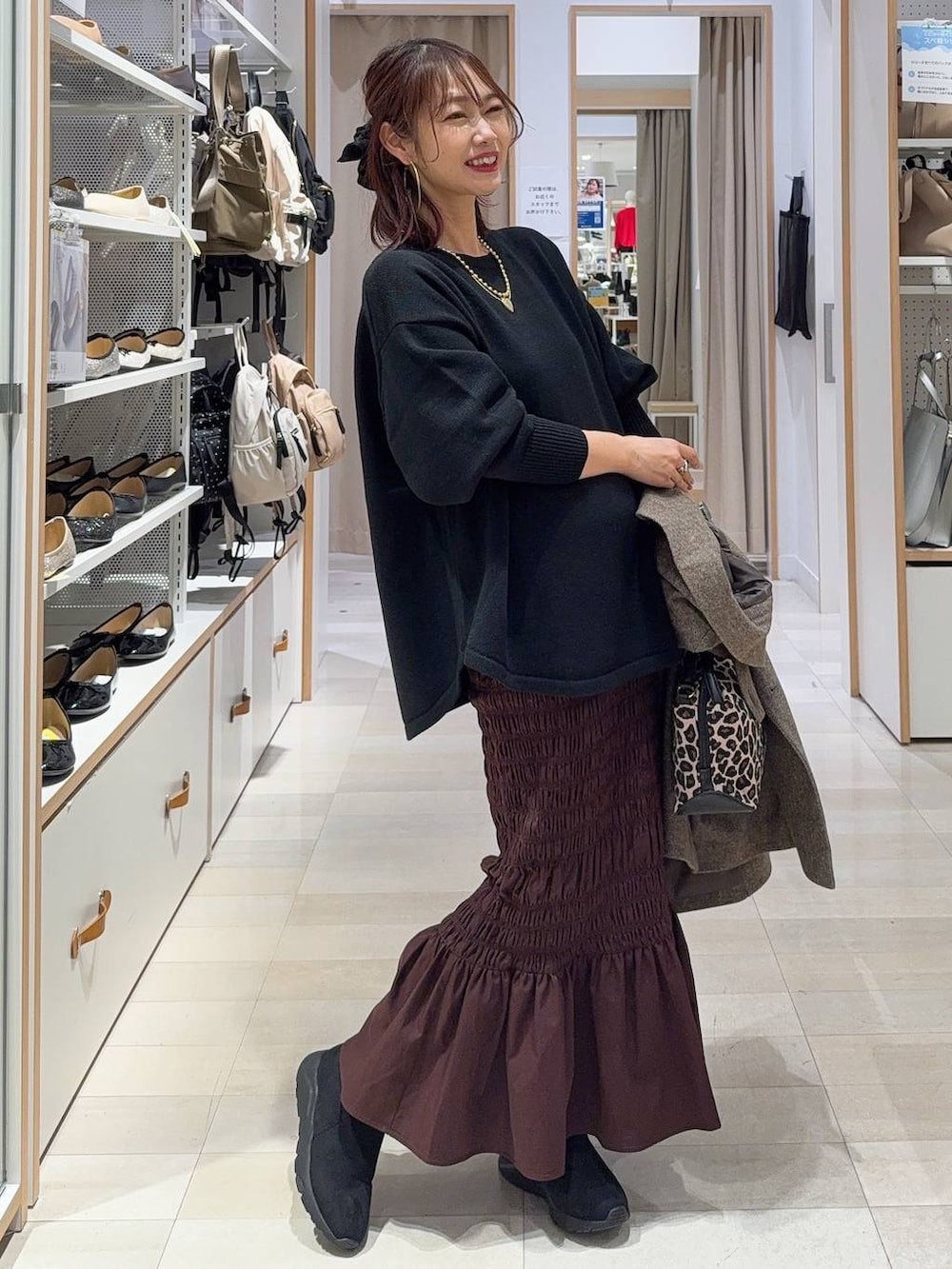 シルバー系のショルダーバッグ、ブラック系のバレエシューズ、ホワイト系のキャミソールを着用したレディースの冬コーディネートの3枚目の写真