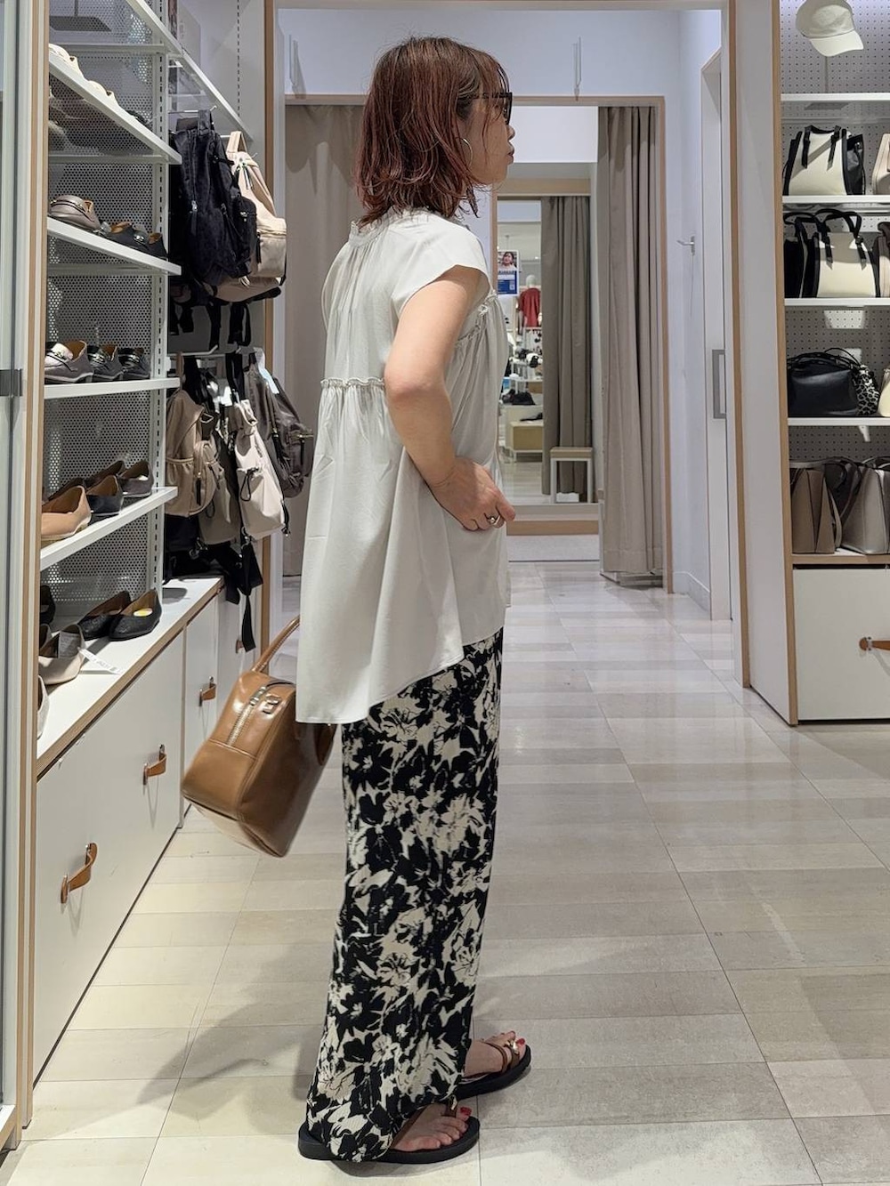 ブルー系のデニムパンツ、ブラック系のショルダーバッグ、ブラック系のサンダルを着用したレディースの夏コーディネートの5枚目の写真