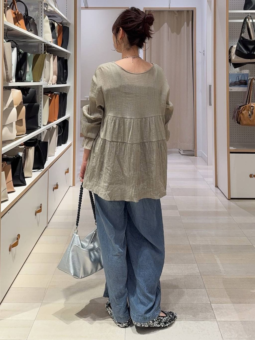 ホワイト系のブルゾン、ブルー系のデニムパンツを着用したレディースの春コーディネートの5枚目の写真