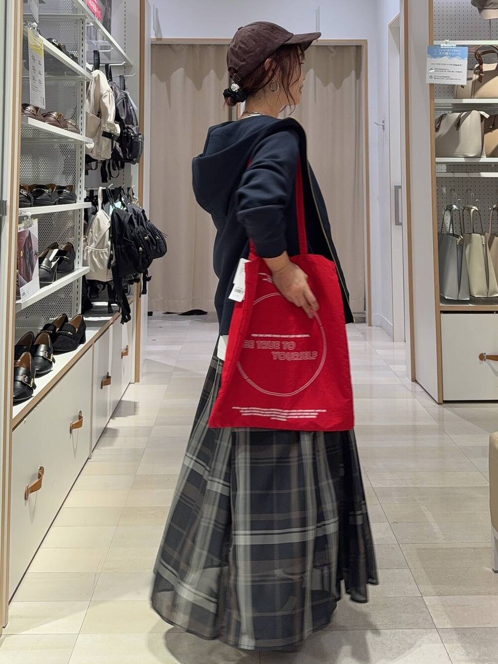 ブラック系のスニーカー、ブラック系のスカート、ホワイト系のTシャツ/カットソーを着用したレディースの秋コーディネートの3枚目の写真