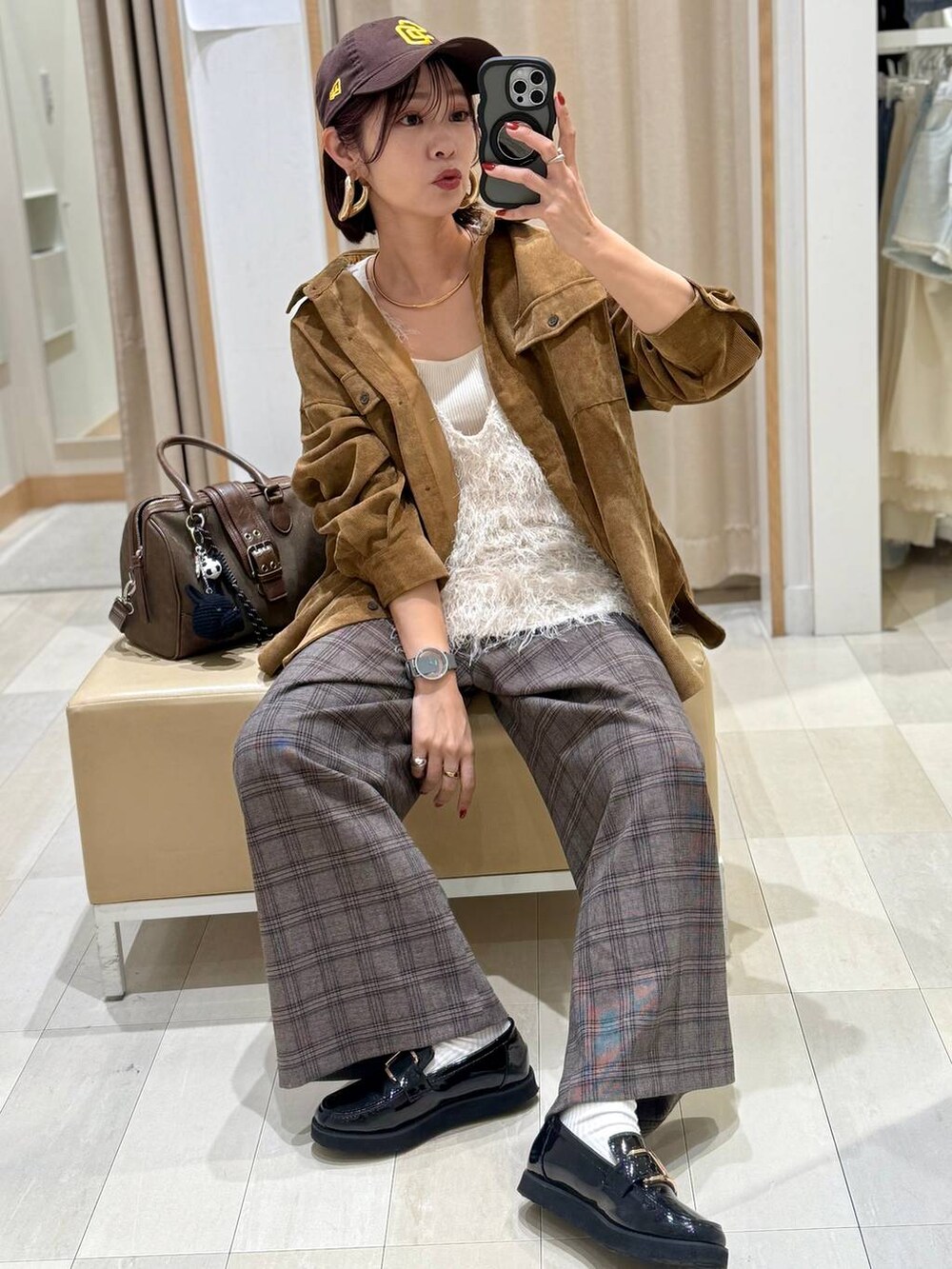 ブラック系のローファー、グリーン系のボストンバッグ、イエロー系のシャツ/ブラウスを着用したレディースの秋コーディネートの2枚目の写真