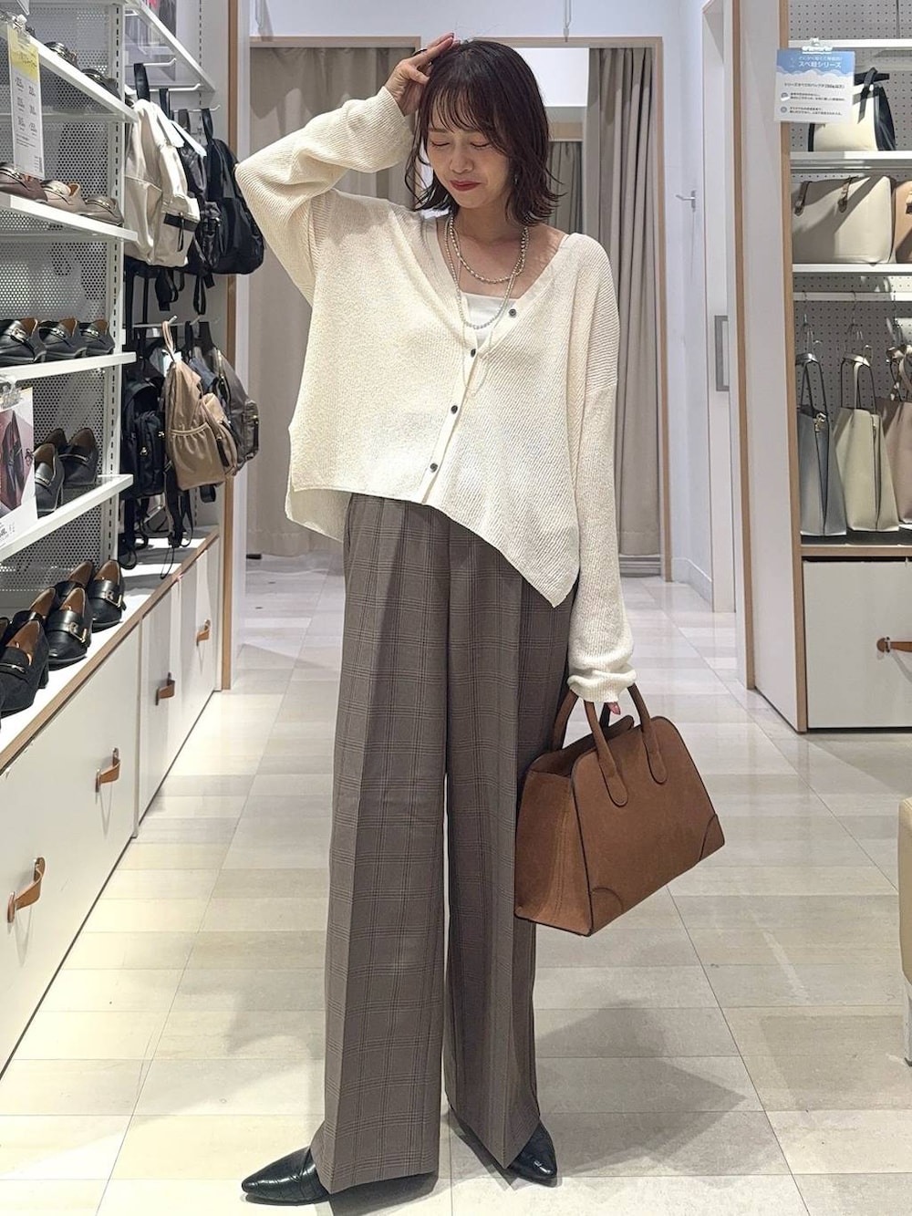 ブラック系のパンプス、ブラック系のキャミソール、ブラウン系のスラックスを着用したレディースの秋コーディネートの3枚目の写真