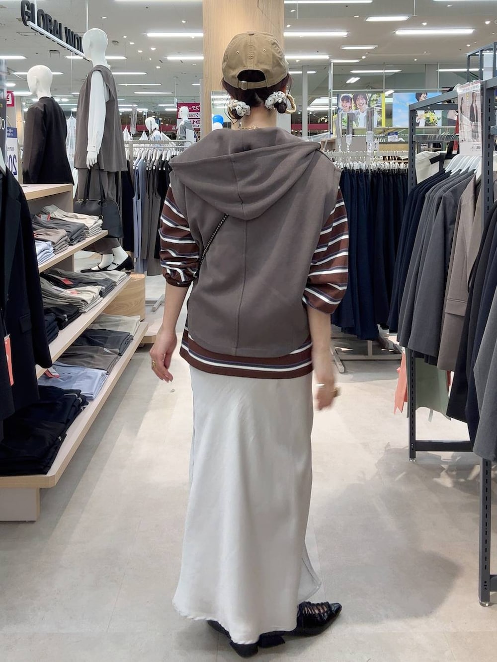 ブラック系のショルダーバッグ、グレー系のスカート、ブラウン系のTシャツ/カットソーを着用したレディースの春コーディネートの4枚目の写真