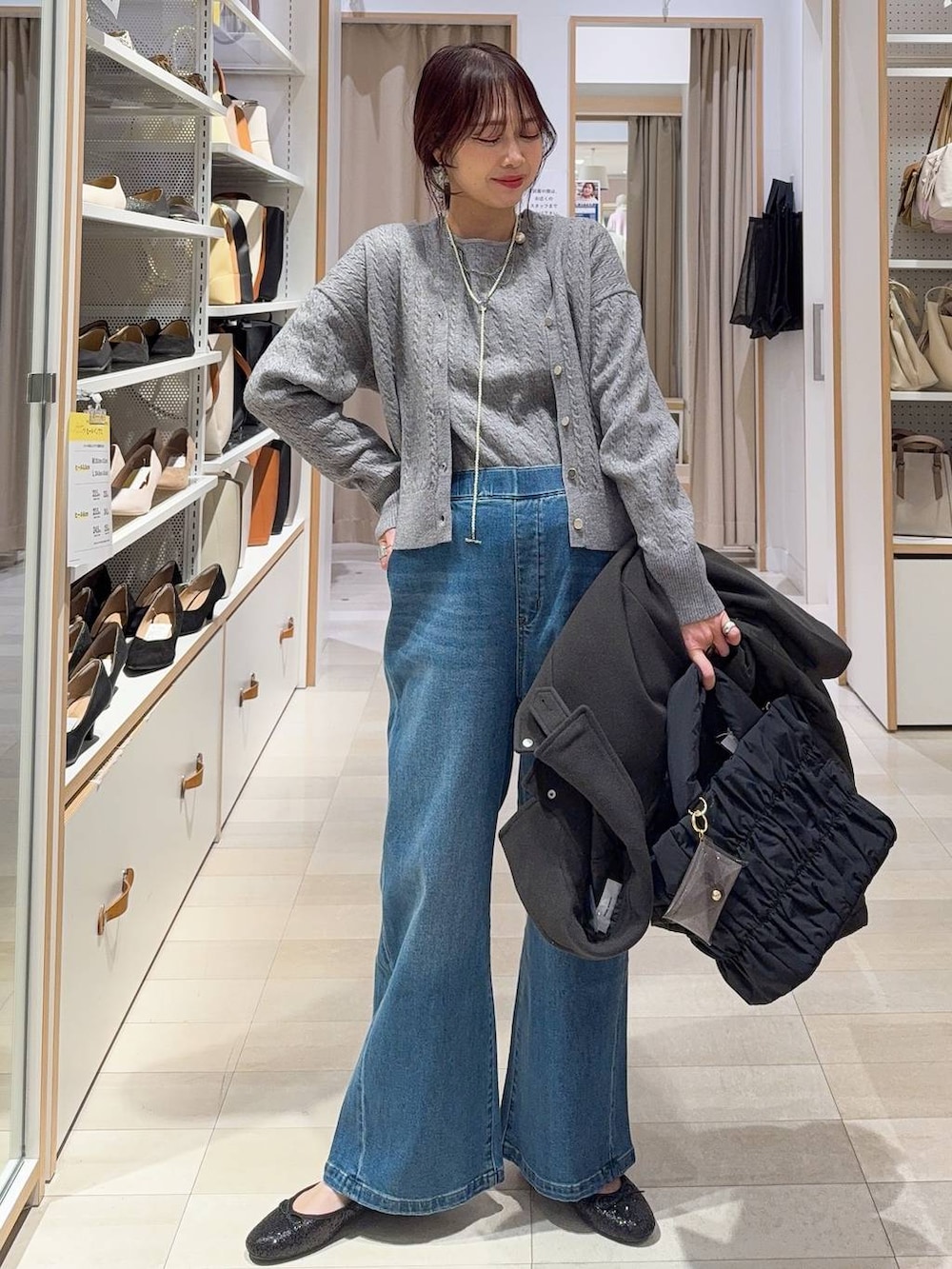 ブラック系のバレエシューズ、ブラウン系のステンカラーコート、ブルー系のデニムパンツを着用したレディースの冬コーディネートの3枚目の写真