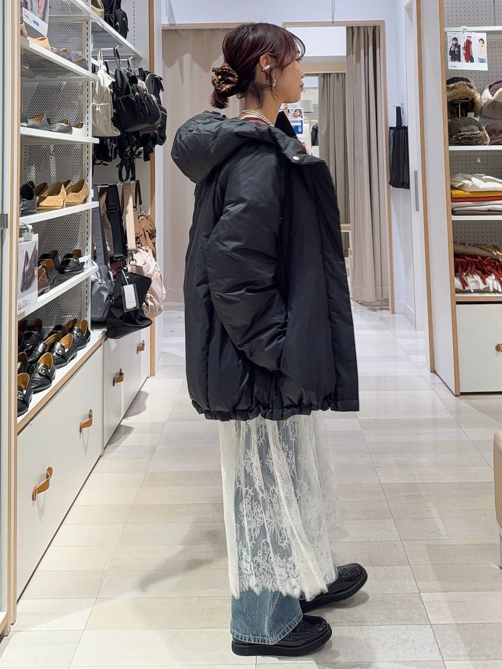 ブラック系のローファー、ブラック系のショルダーバッグ、ブラック系のダウンジャケット/コートを着用したレディースの冬コーディネートの6枚目の写真