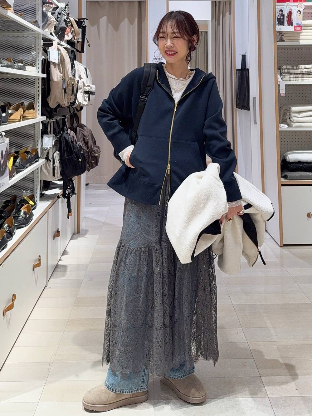 ホワイト系のブルゾン、ブルー系のデニムパンツ、ブラック系のバックパック/リュックを着用したレディースの冬コーディネートの2枚目の写真