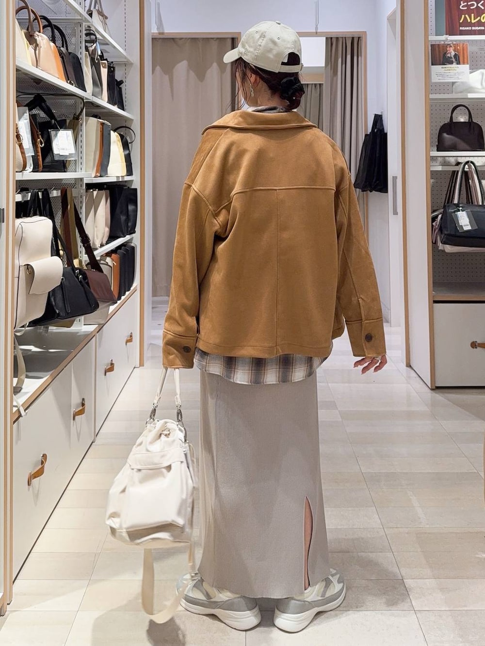 ホワイト系のショルダーバッグ、ホワイト系のスニーカー、ブラウン系のテーラードジャケットを着用したレディースの冬コーディネートの5枚目の写真