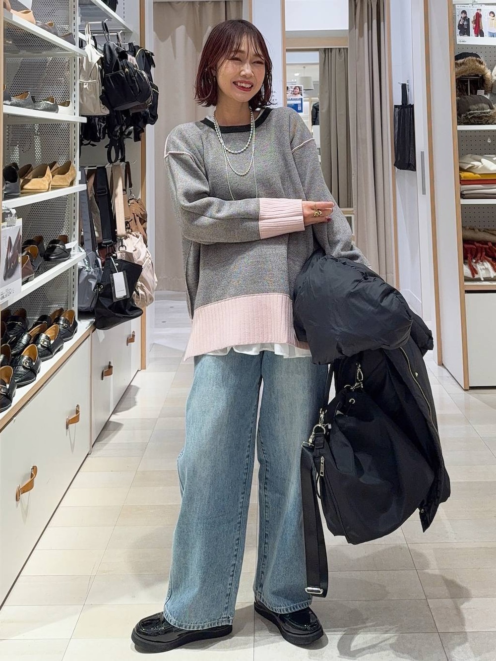 ブラック系のショルダーバッグ、ベージュ系のダウンジャケット/コート、ブラック系のその他パンツを着用したレディースの冬コーディネートの3枚目の写真