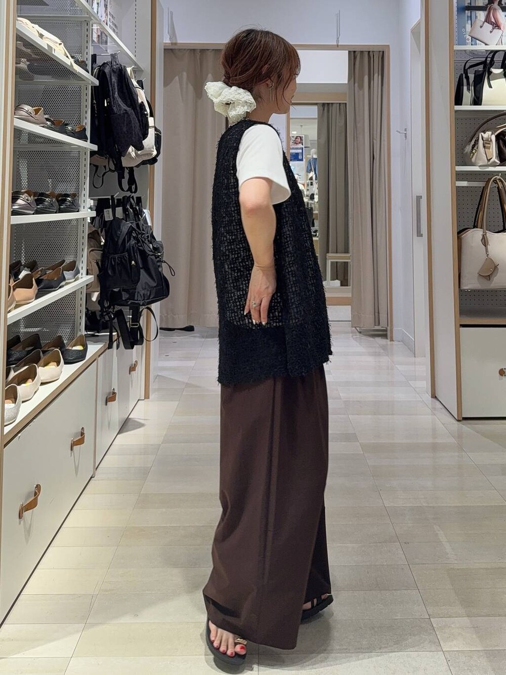 ブルー系のジャンパースカート、ベージュ系のボストンバッグ、ブラック系のサンダルを着用したレディースの夏コーディネートの5枚目の写真