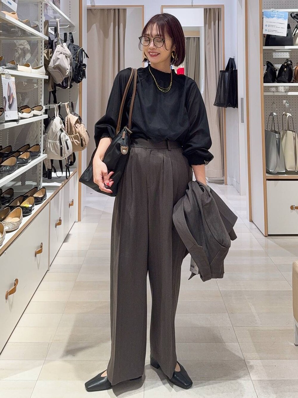 ブラック系のトートバッグ、ブラック系のシャツ/ブラウス、ブラック系のその他シューズを着用したレディースの秋コーディネートの2枚目の写真