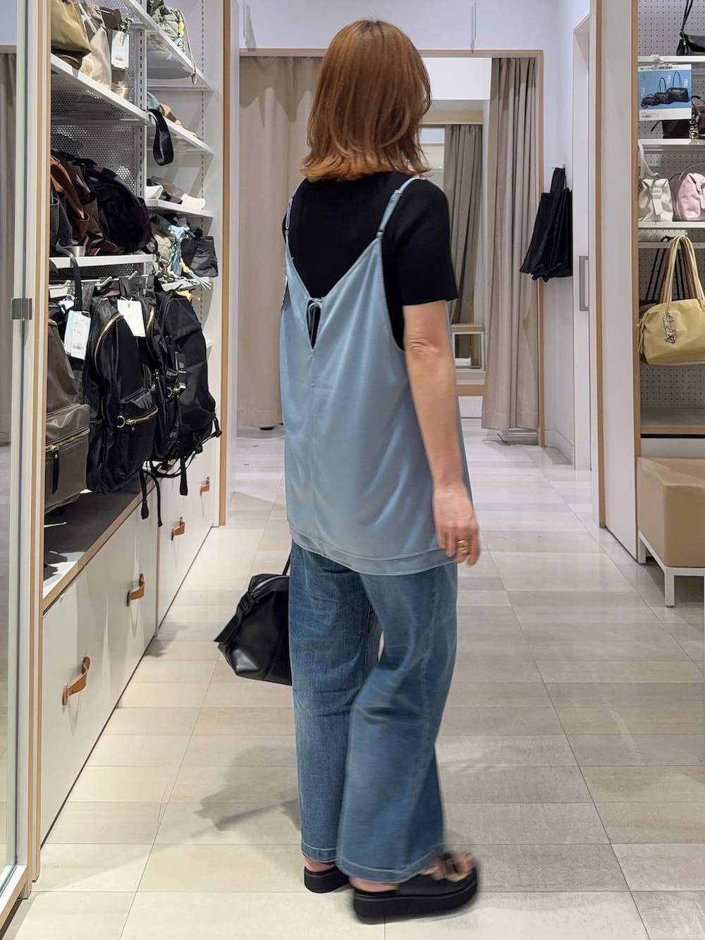 ホワイト系のキャミソール、ブルー系のデニムパンツ、ブラック系のニット/セーターを着用したレディースの春コーディネートの8枚目の写真