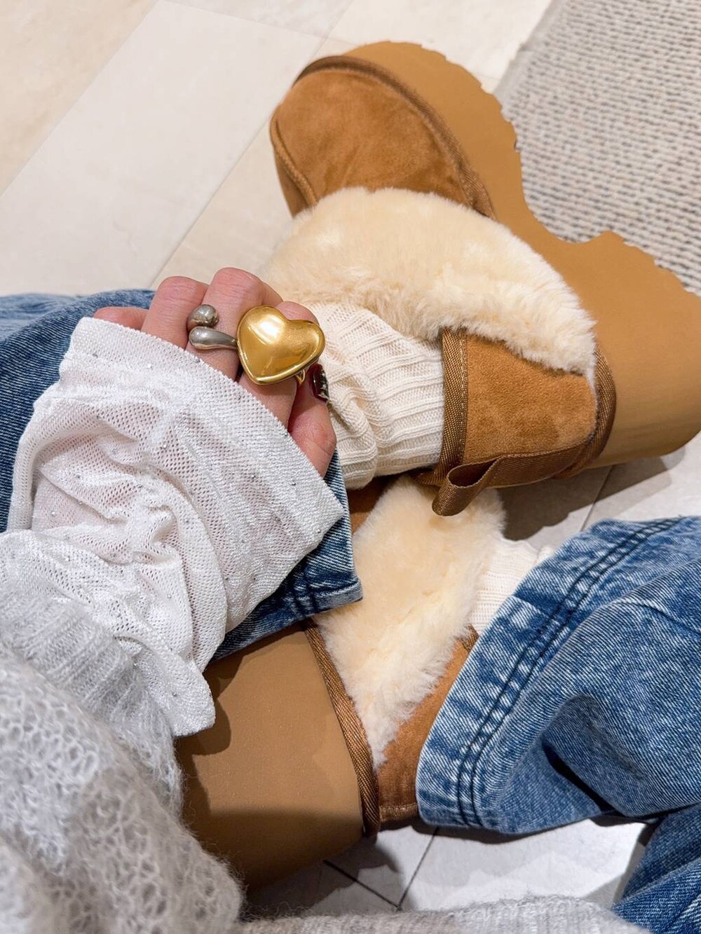 ブラック系のショルダーバッグ、グレー系のニット/セーター、イエロー系のブーツを着用したレディースの冬コーディネートの2枚目の写真