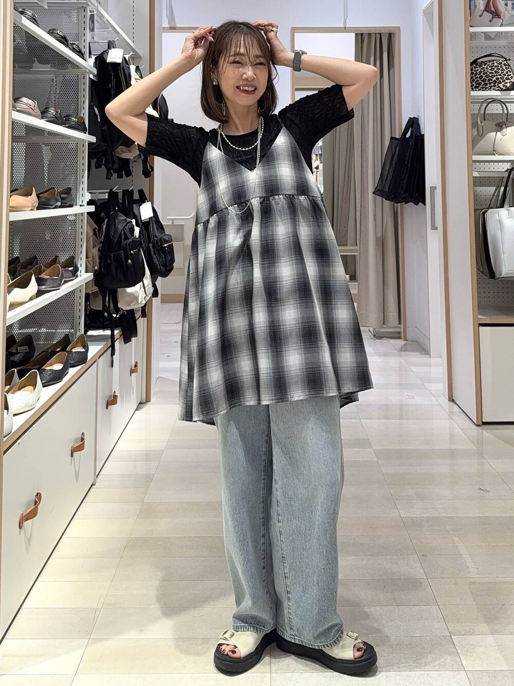 ブルー系のデニムパンツ、ホワイト系のキャミソール、ブラック系のキャミソールを着用したレディースの夏コーディネートの3枚目の写真