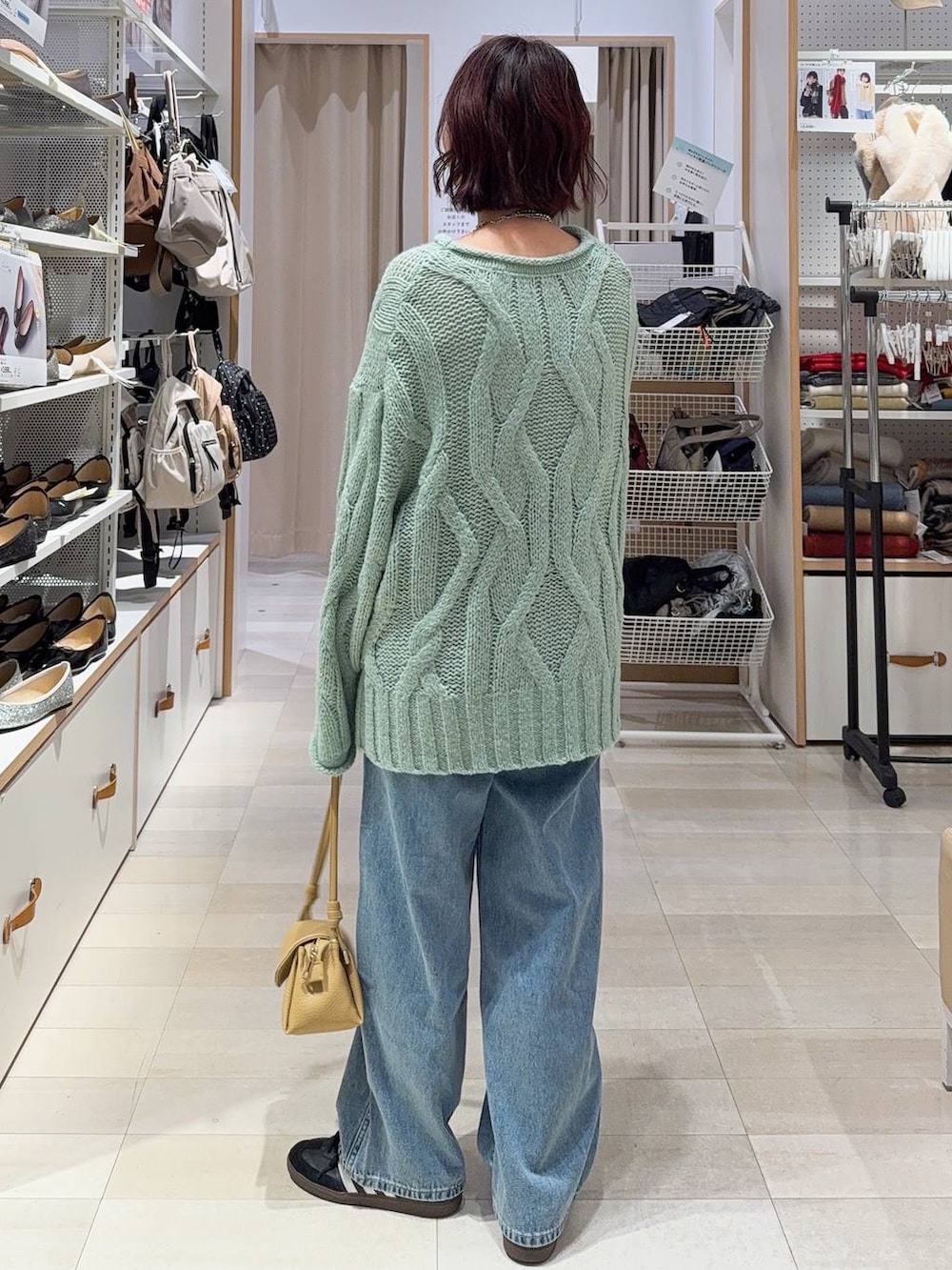 ブルー系のデニムパンツ、イエロー系のショルダーバッグ、ホワイト系のステンカラーコートを着用したレディースの冬コーディネートの8枚目の写真