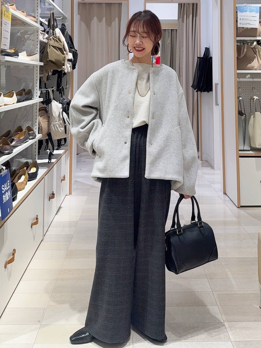 ブラック系のその他シューズ、グレー系のノーカラーコート、ブラック系のボストンバッグを着用したレディースの秋コーディネートの2枚目の写真