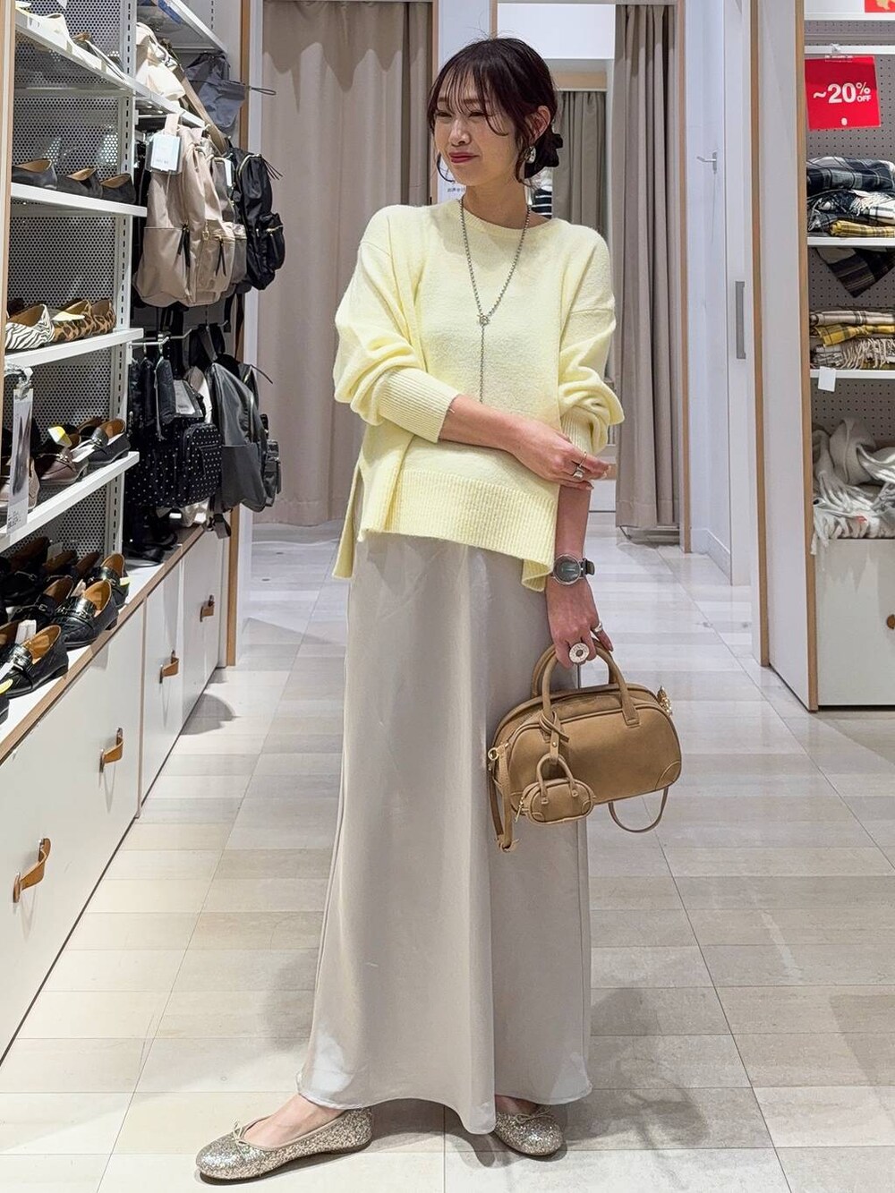 ブラック系のボストンバッグ、ホワイト系のブルゾン、イエロー系のニット/セーターを着用したレディースの冬コーディネートの5枚目の写真